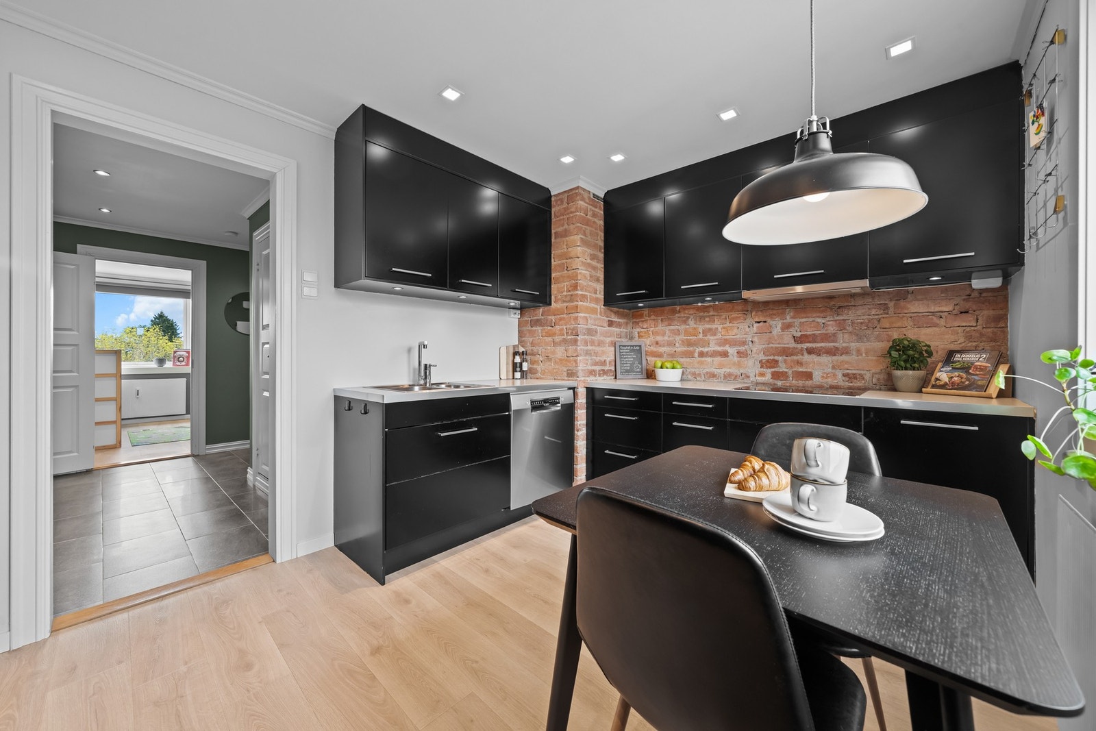 Kjøkkenet har kjøleskap, fryseskap, stekeovn og induksjonstopp, samt kullfilterventilator, benkestikk og opplegg for oppvaskmaskin Galleribilde