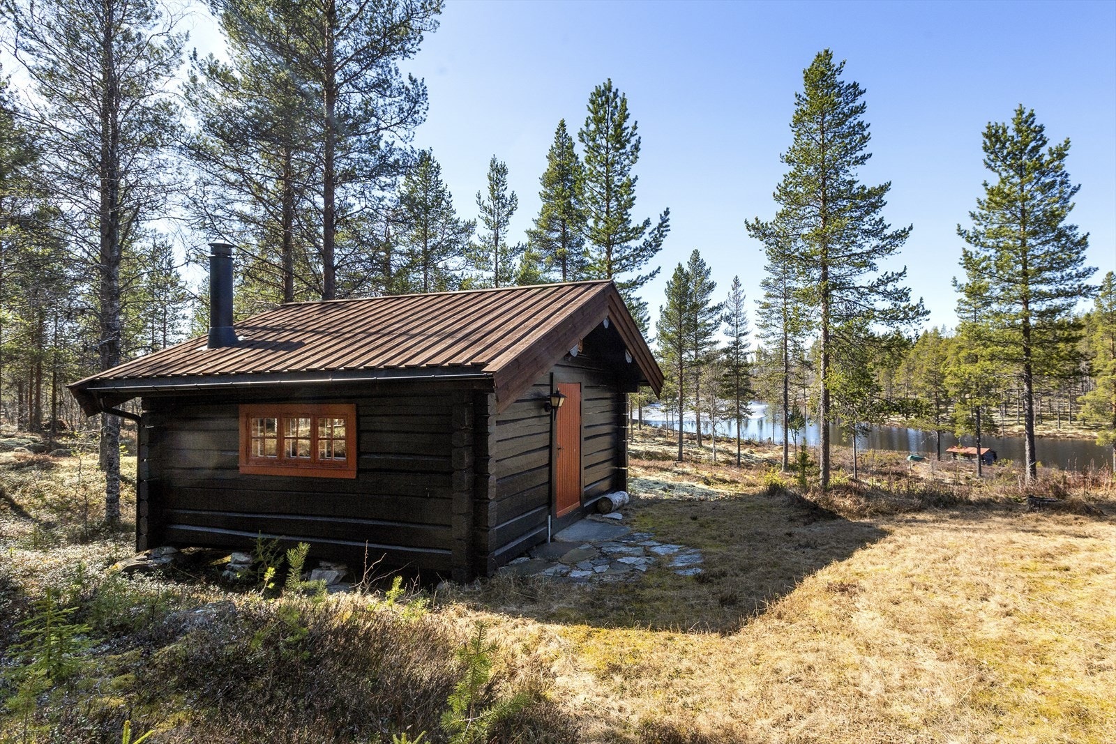 Annekset er en maskinlaftet tømmerhytte bygd på 90-tallet med grunnmur av steinblokker. Den fikk nytt overtak og ovn/pipe i 2021 Galleribilde