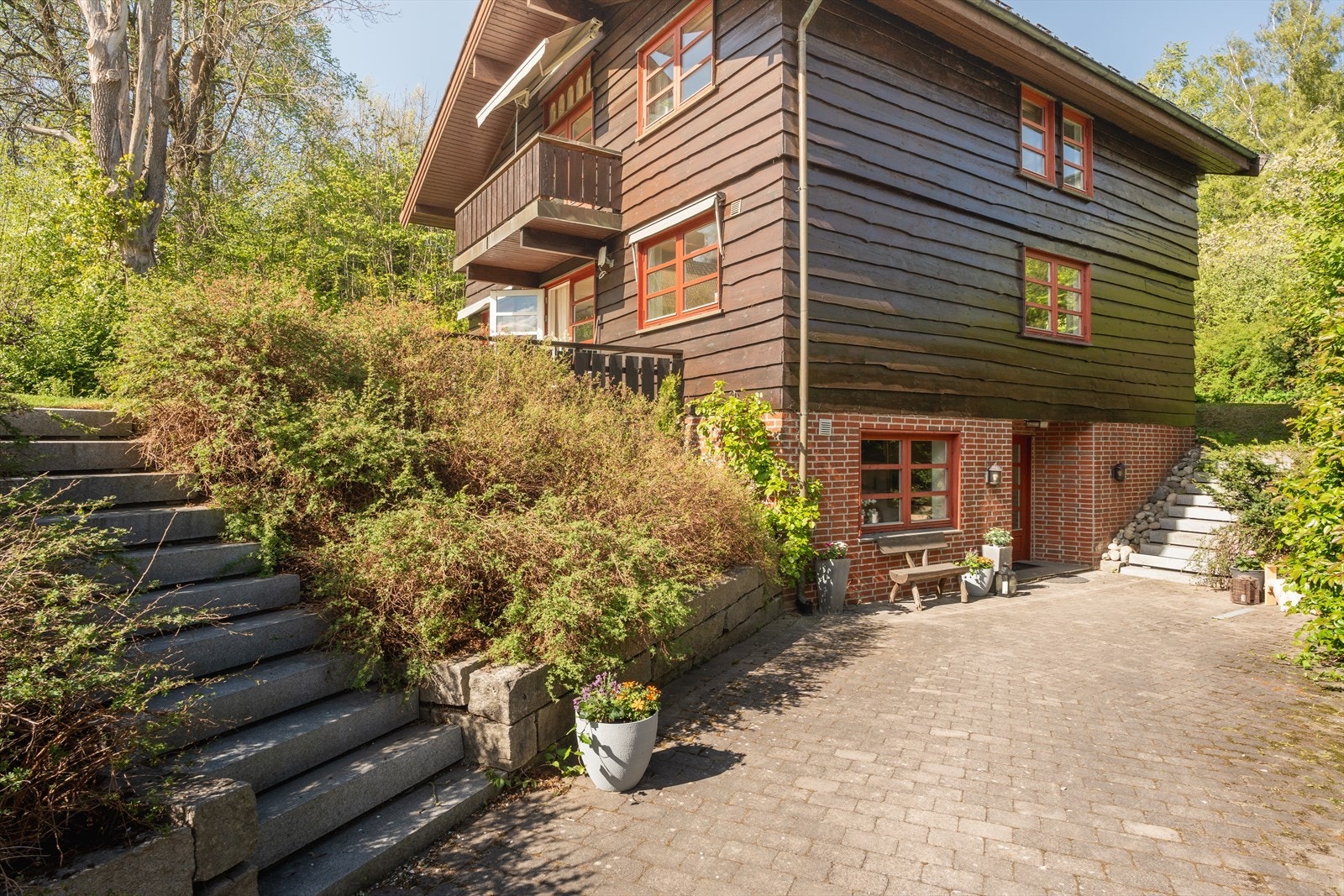 Pent brosteinsbelagt gårdsplass, hvor du kan nyte morgensolen. Frodig og lettstelt hage, med variert beplantning. Her kan barna lære seg å sykle i bilfrie omgivelser Galleribilde