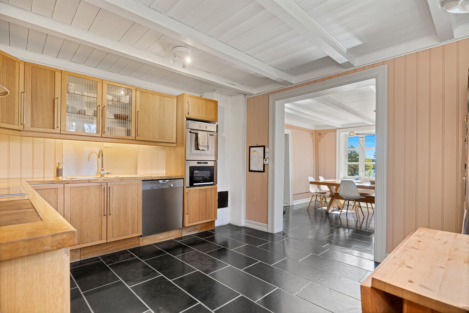 Fra kjokken hvor det er godt med skap og benkplass mot spisestuen. Galleribilde