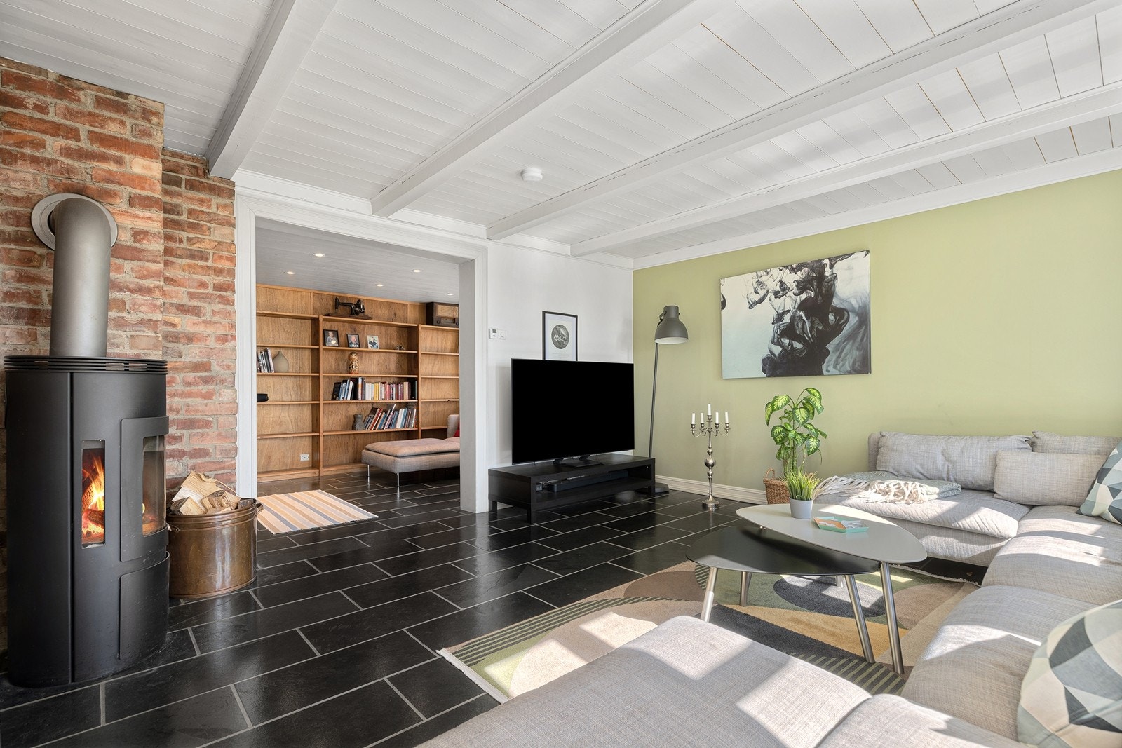 Stue med peisovn. Biblioteket i bakkant. Galleribilde