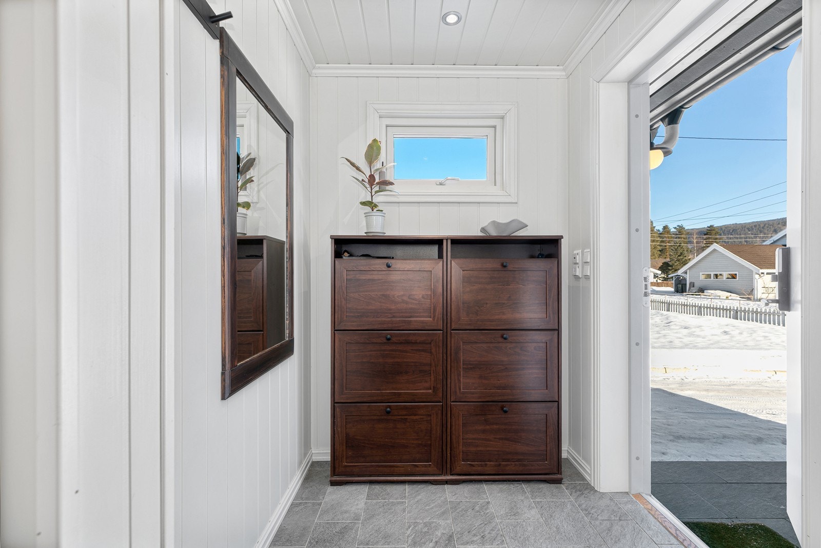 Man ønskes velkommen inn i en lys og innbydende entré med gulvvarme og plass til oppbevaring av sko og yttertøy. Galleribilde