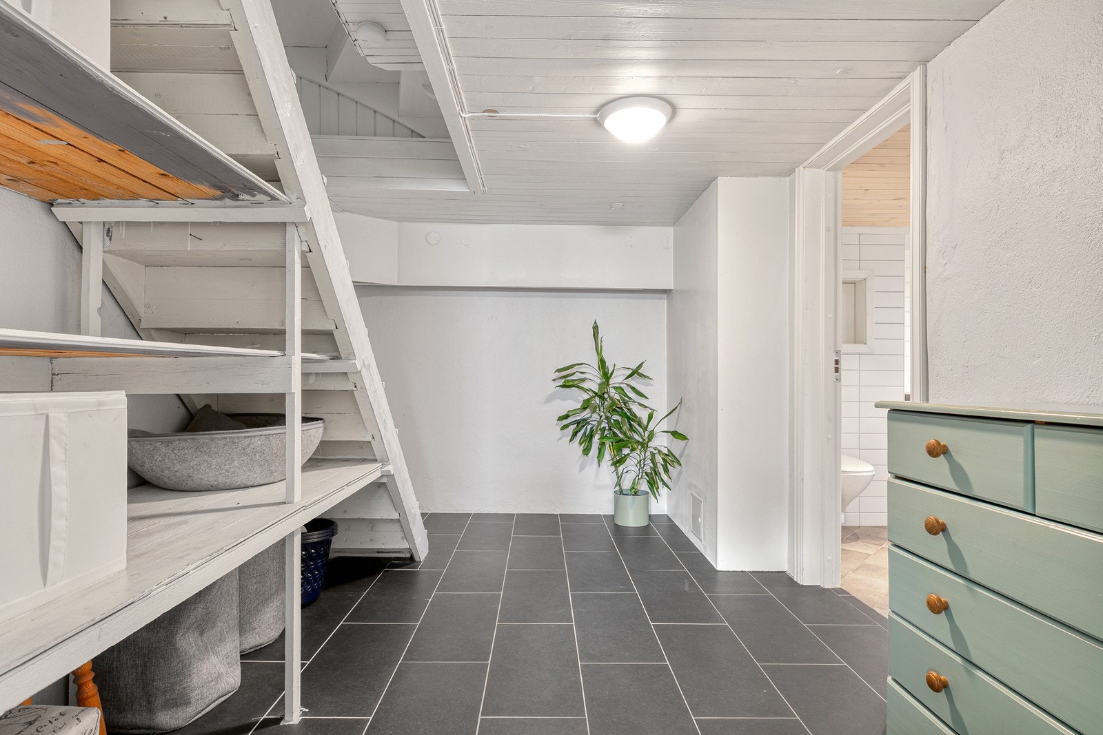 Velkommen ned! Her nede har man gode lagringsmuligheter samt et praktisk kombinasjonsrom som er innredet til bad/vaskerom. Galleribilde