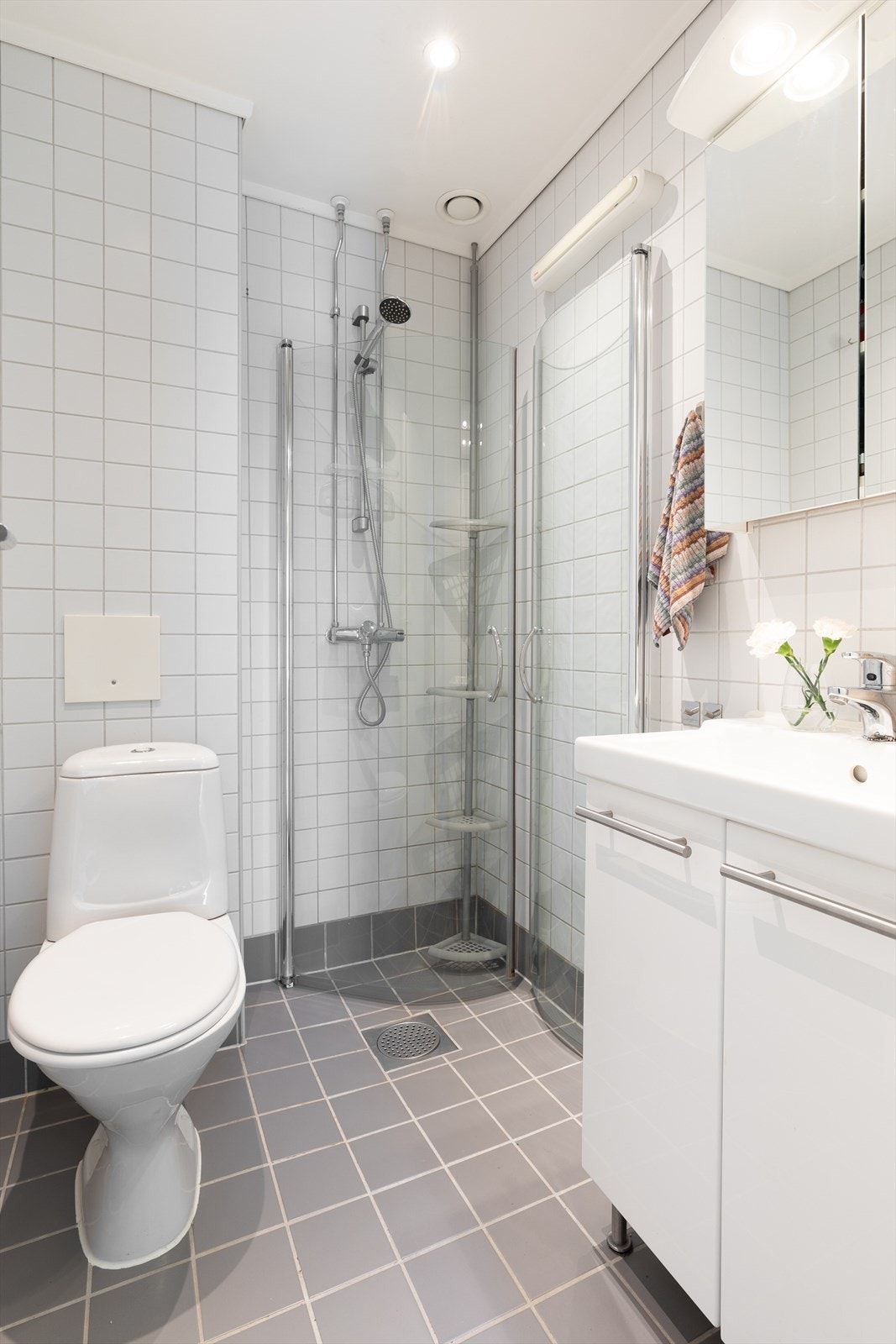 Badet er fra 2006 og inneholder alt dere trenger!
Her får dere dusjhjørne med veggmonterte dusjdører, servant med underskap, speilskap med lys og wc. Fellesvaskeri er plassert i samme etasje som leiligheten (et vaskeri i hver etasje). Galleribilde