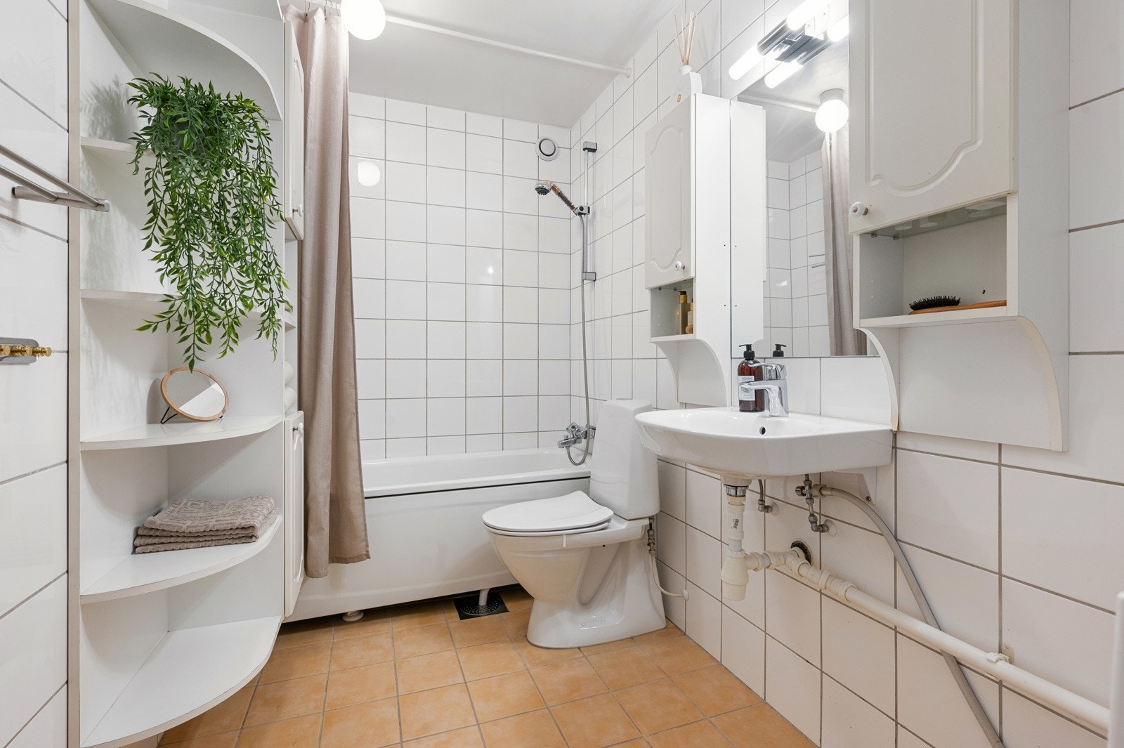 Flislagt bad av god størrelse med opplegg for vaskemaskin og tørketrommel. Galleribilde