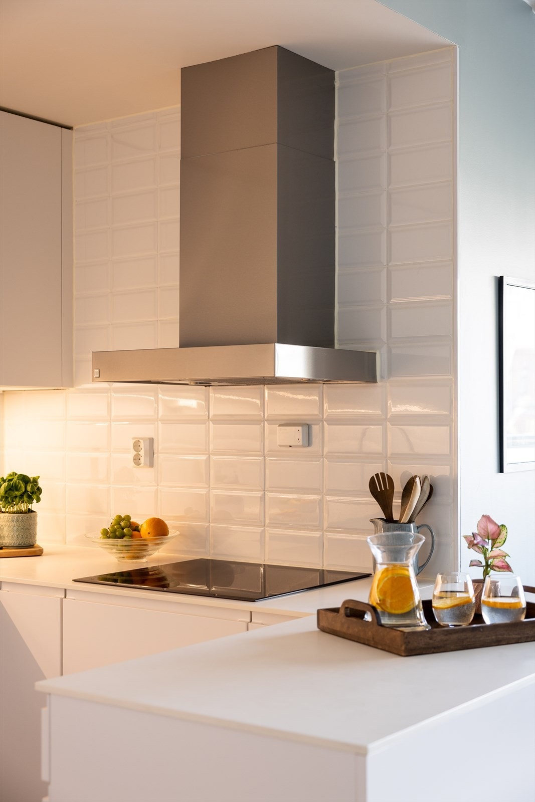 Lekre materialvalg og fliser fra benk opp til tak bak kjøkkenviften. Galleribilde