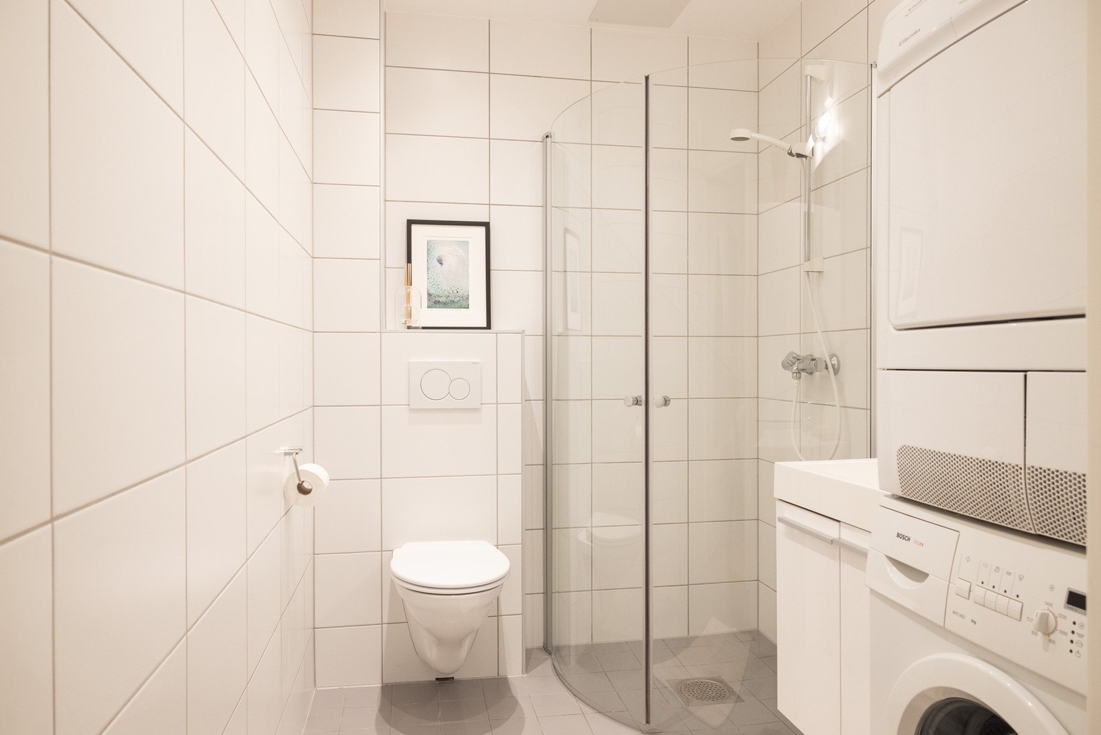 Badet består av servantskap med nedfelt servant, vegghengt toalett og dusjhjørne med innfellbare dusjdører. Galleribilde