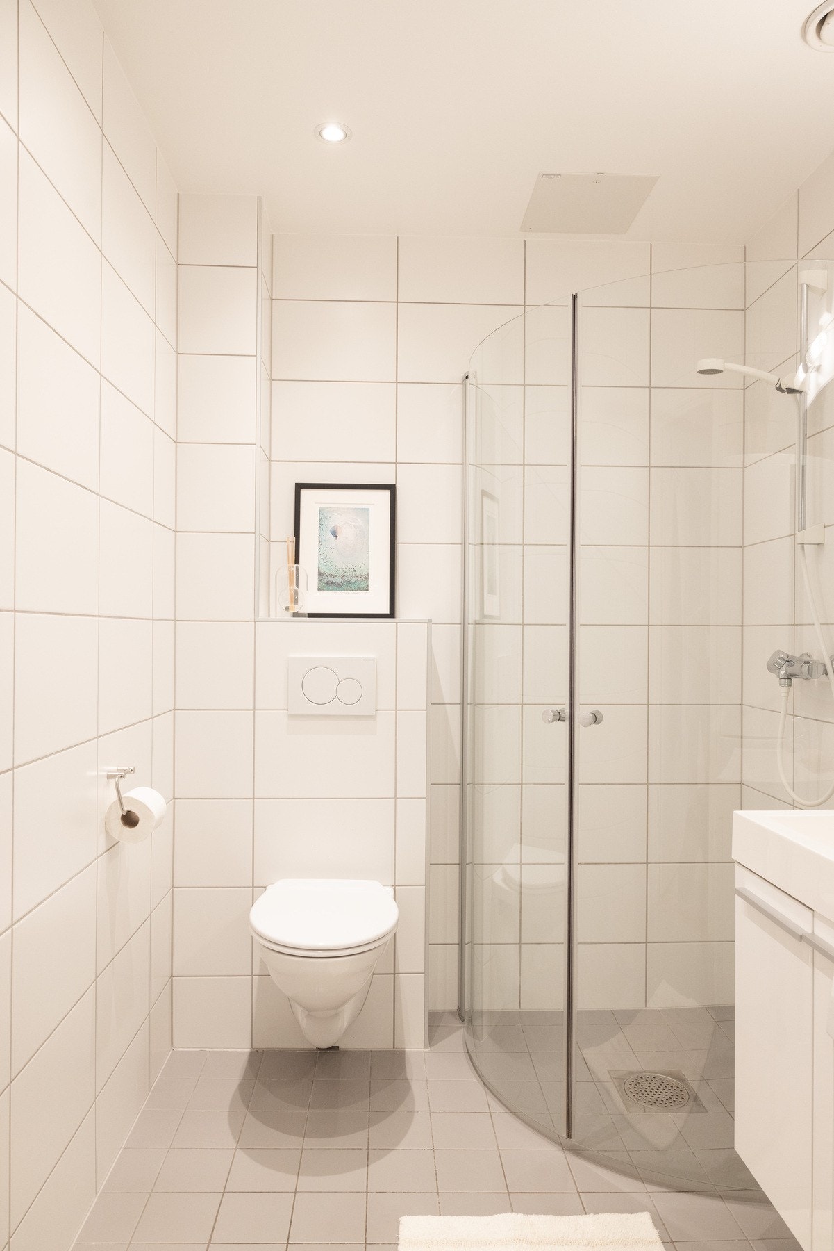 Flislagt baderom med varmekabler i gulv og downlights i himling. Galleribilde