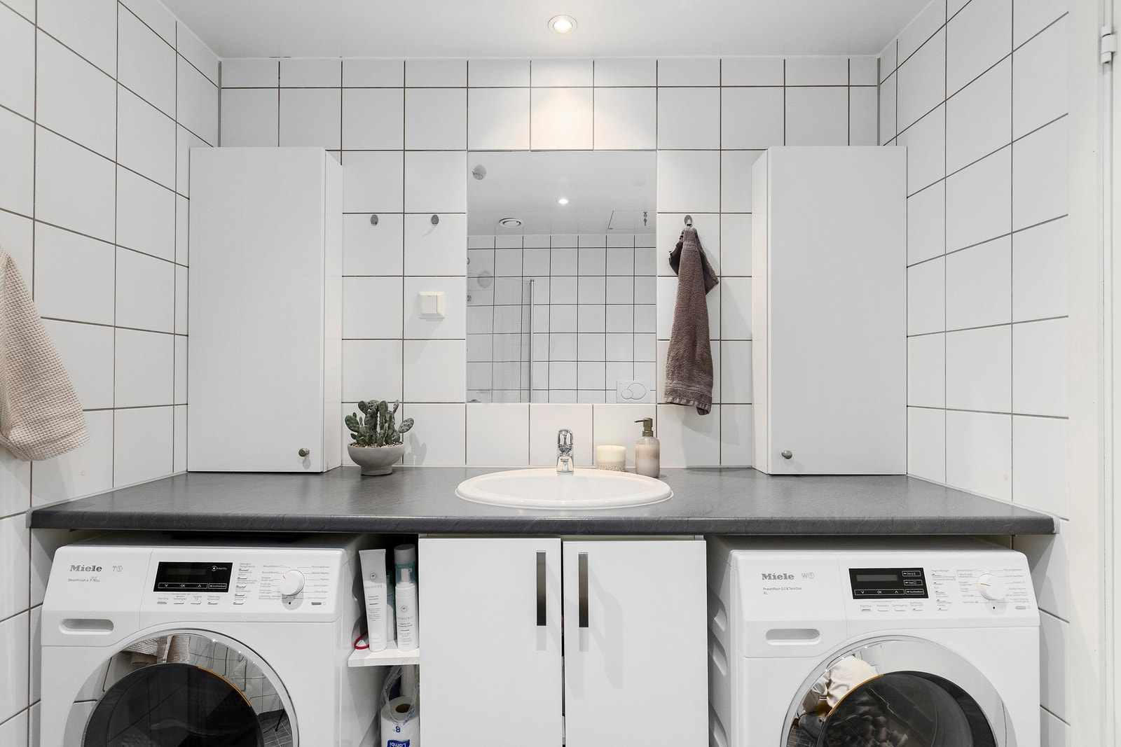 Badet har en praktisk utforming med plass til både vaskemaskin og tørketrommel under benken. Galleribilde