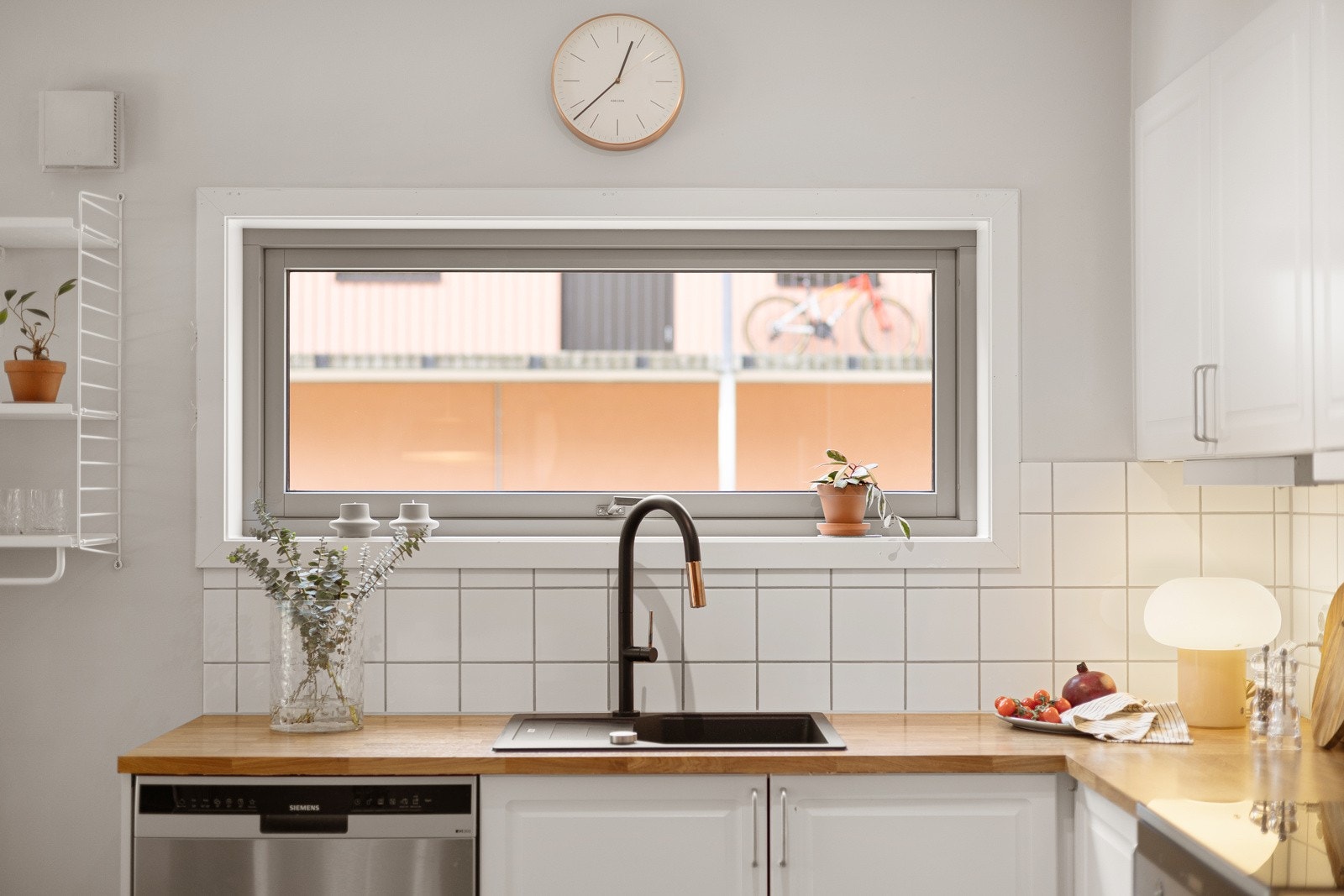 Frittstående hvitevarer. Side-by-side kjøl/fryseskap, oppvaskmaskin under benk og komfyr med induksjonstopp. Ventilator i overskap. Galleribilde