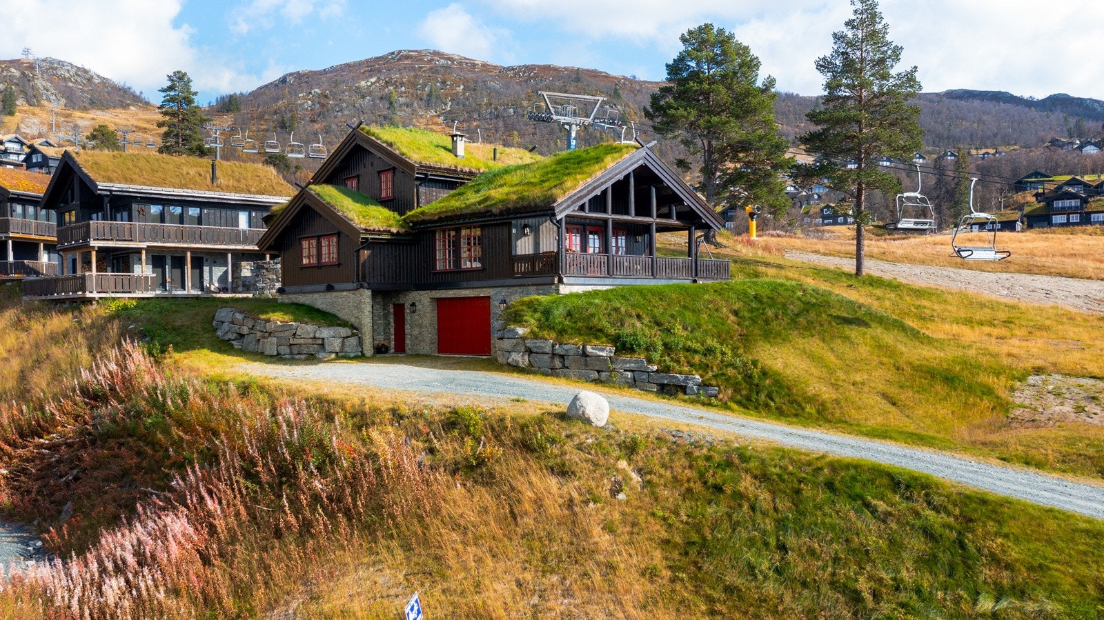 Grunnmur kledd i skiferstein og fine steinmurer opp til eiendommen Galleribilde