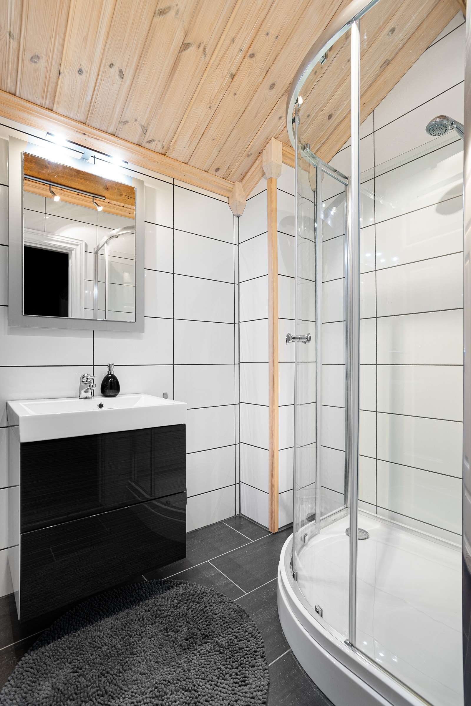 Pent helfliset bad som inneholder servant med innredning, dusjkabinett og toalett Galleribilde