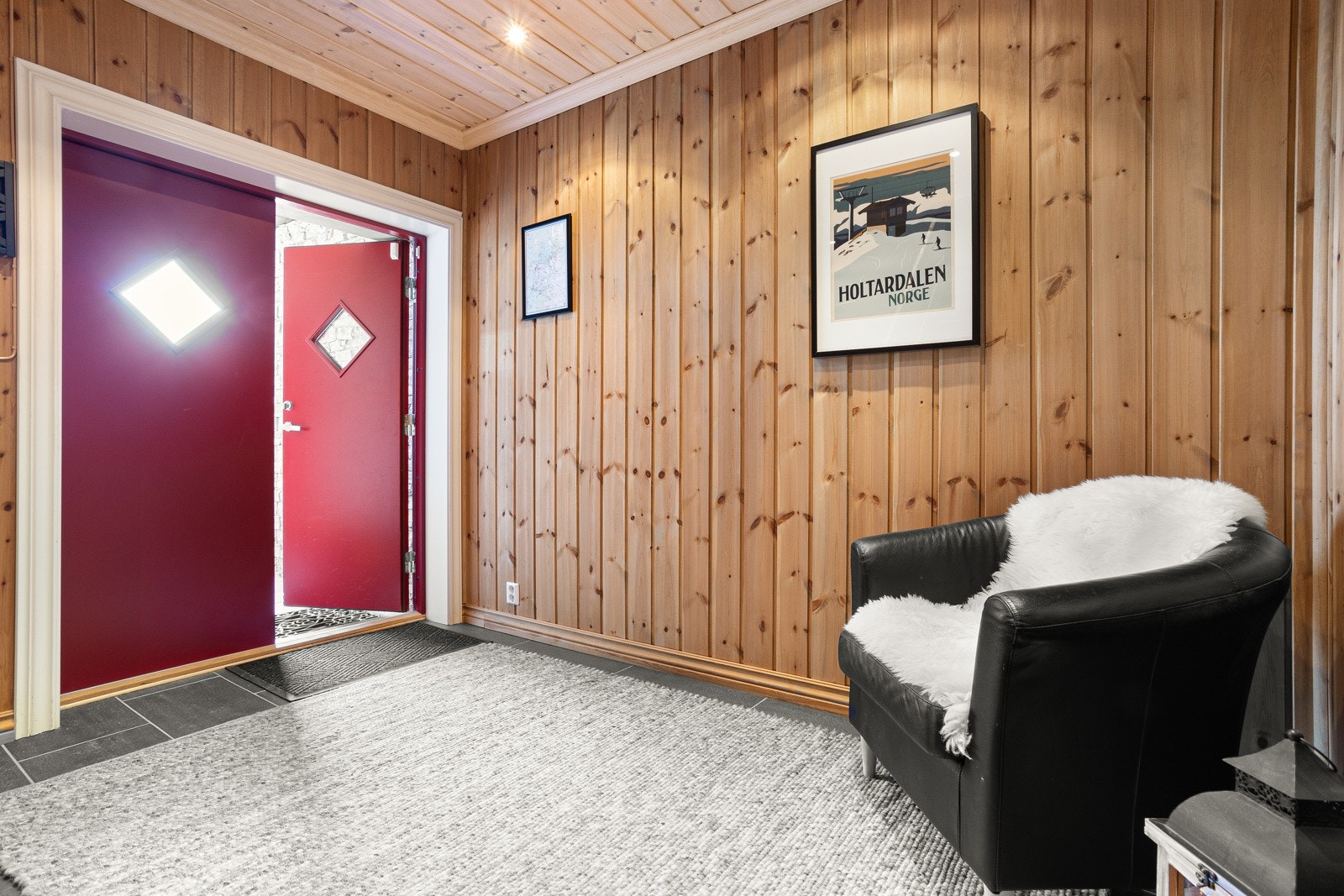 Doble dører inn til en romslig og flislagt hall. Fra hallen har man direkte inngang til vaskerom med garderober, skibod og garasje. Her kommer man tørrskodd inn fra bilen Galleribilde