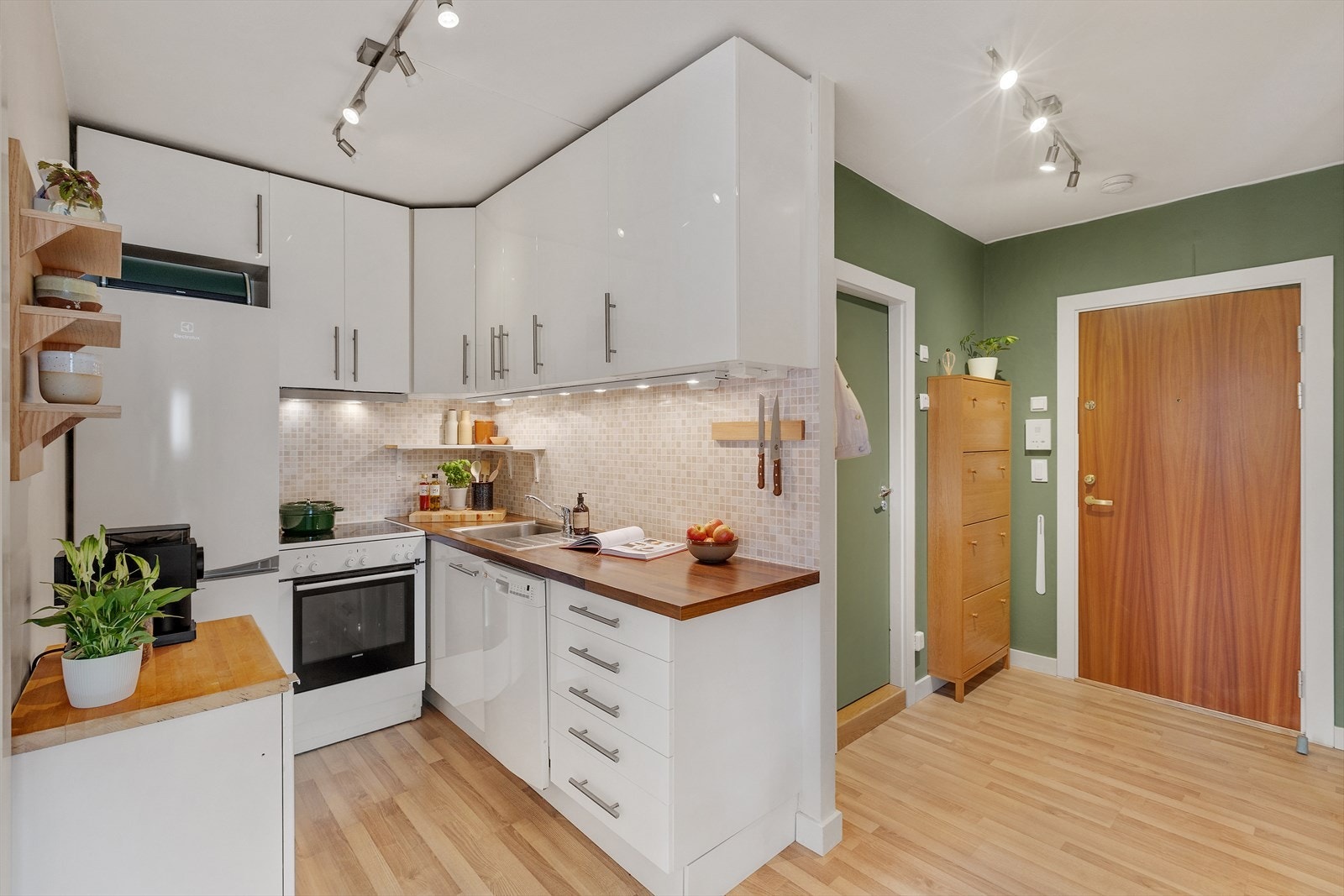 Et skjermet og lyst kjøkken med smarte løsninger og god oppbevaringsplass. Galleribilde