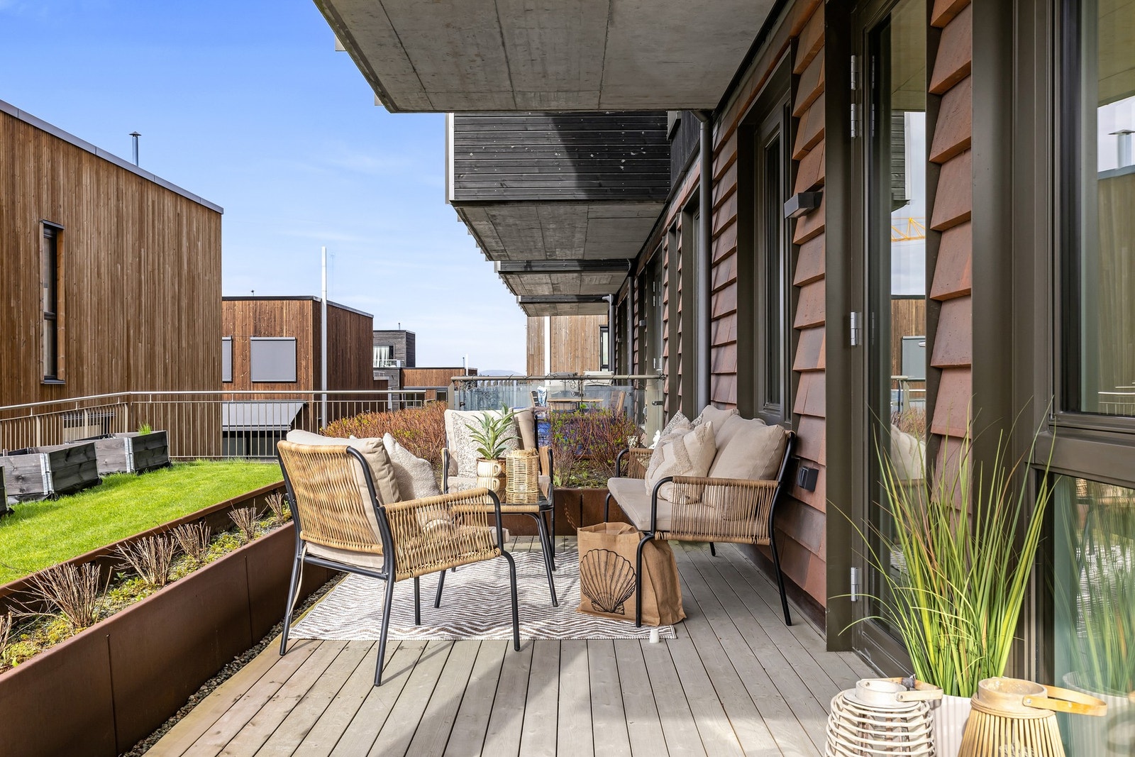 Balkongen vender mot borettslagets pene fellesarealer som er opparbeidet med plener, prydbusker, lekeplasser og internveier. Galleribilde