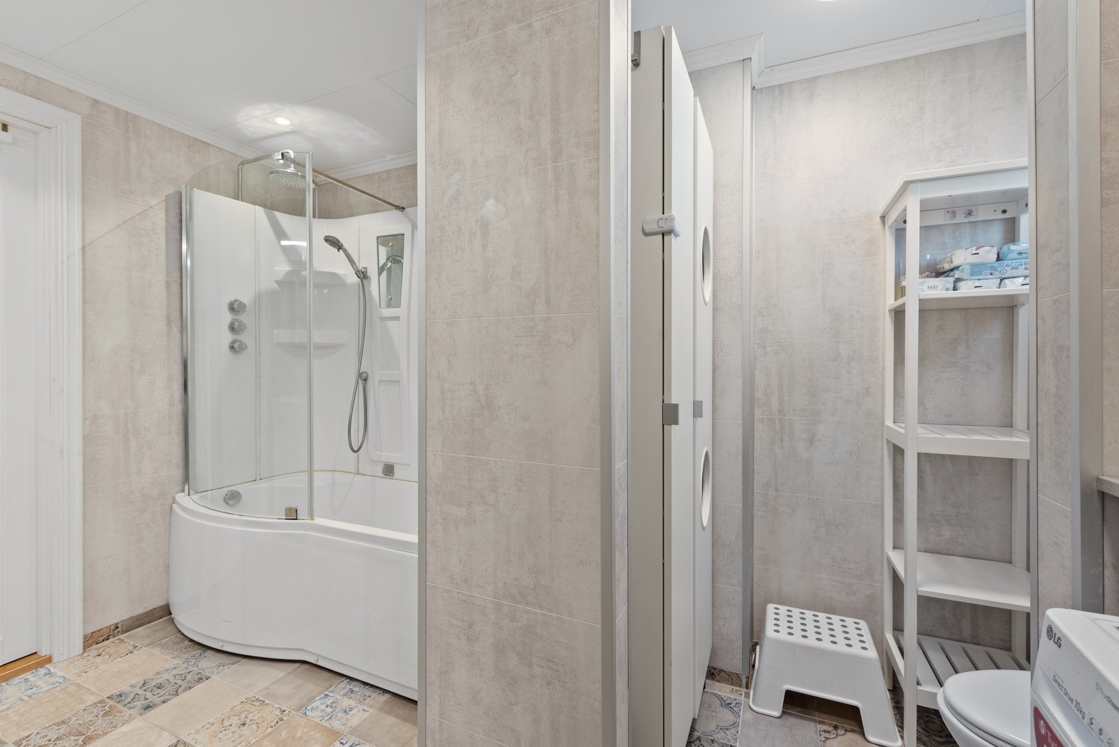 Et praktisk bad med både badekar og vaskemaskin, perfekt for barnefamilien Galleribilde