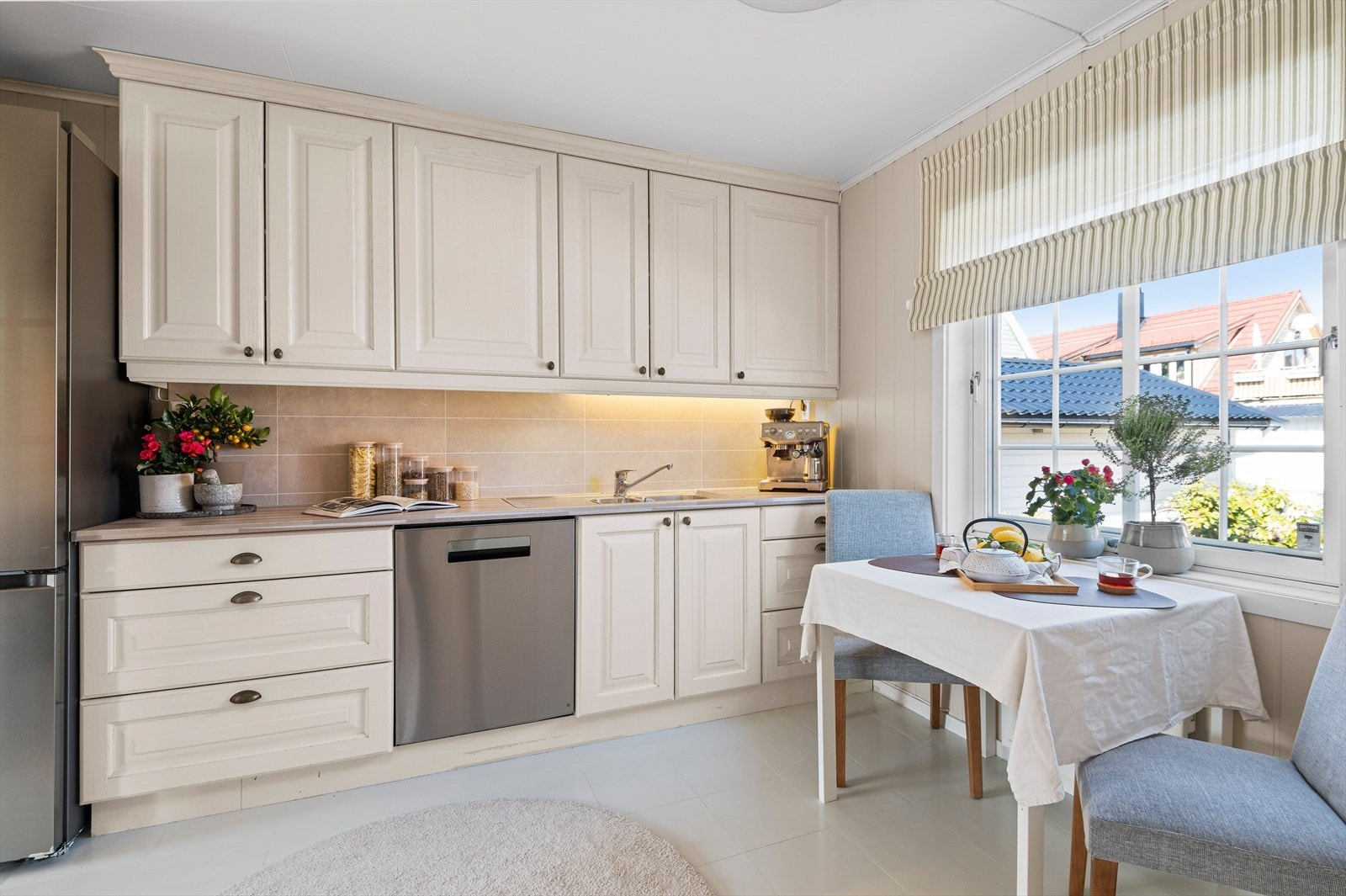 Kjøkkenet i hoveddelen er etablert med hvite profilerte fronter, benkeplate i laminat, nedfelt oppvaskkum med blandebatteri, integrert koketopp, stekeovn og opplegg for oppvaskmaskin. Galleribilde