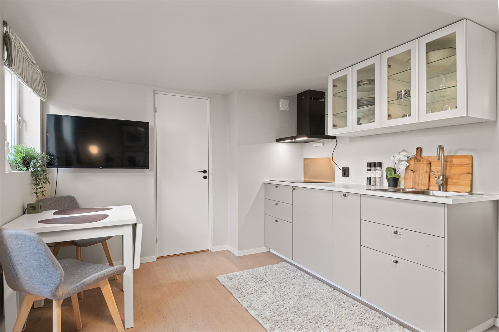 Kjøkkenet er innredet med glatte fronter, benkeplate i laminat, nedfelt oppvaskkum med blandebatteri, integrert koketopp og kjøleskap. Galleribilde