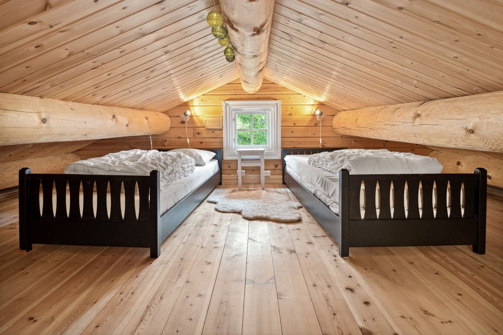 Loft med lavt under tak er innredet med senger. Legg merke til de flotte tømmerstokkene oppunder taket! Galleribilde