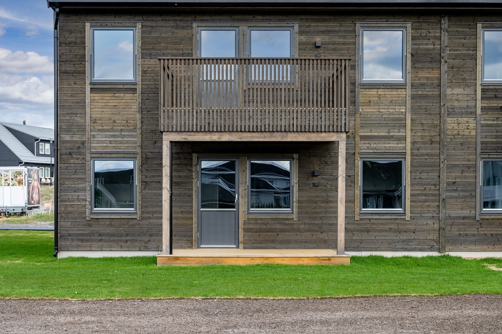 Terrassen er overbygget, har terrassebord på gulv og plass til sittegruppe. Det er også montert utebelysning og utvendig stikkontakt på vegg. Galleribilde