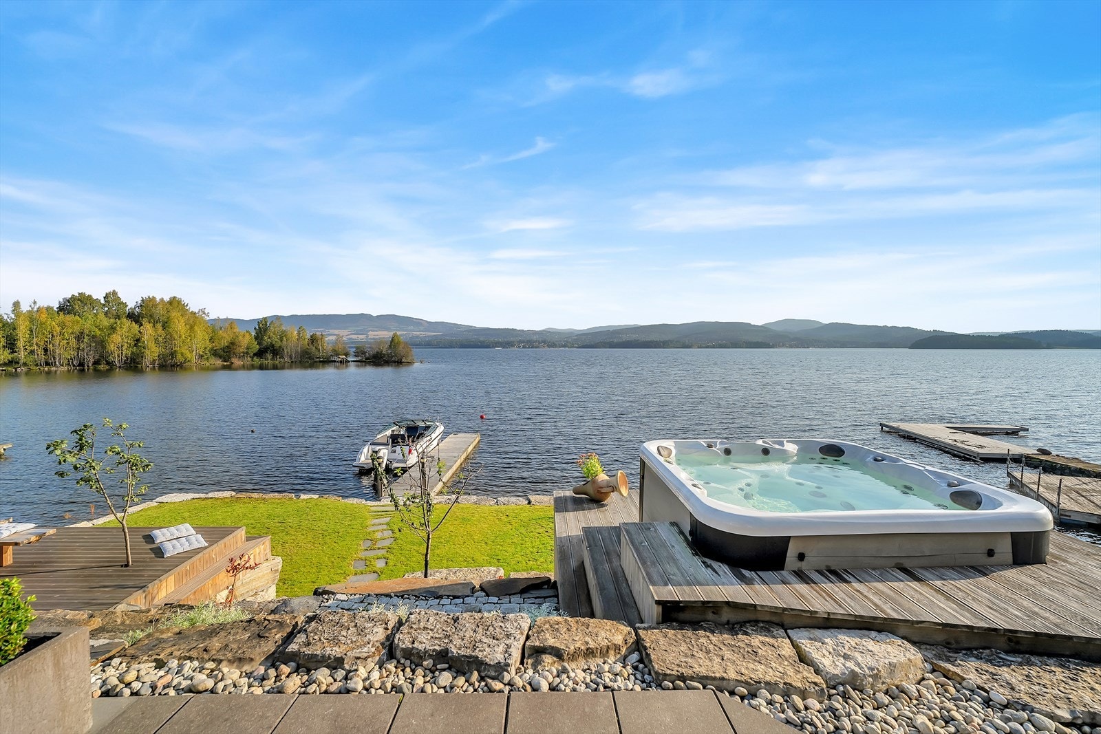Tomten er pent opparbeidet og strekker seg over flere nivåer. Her har du også jacuzzi til dager hvor Mjøstemperaturen ikke frister. Galleribilde