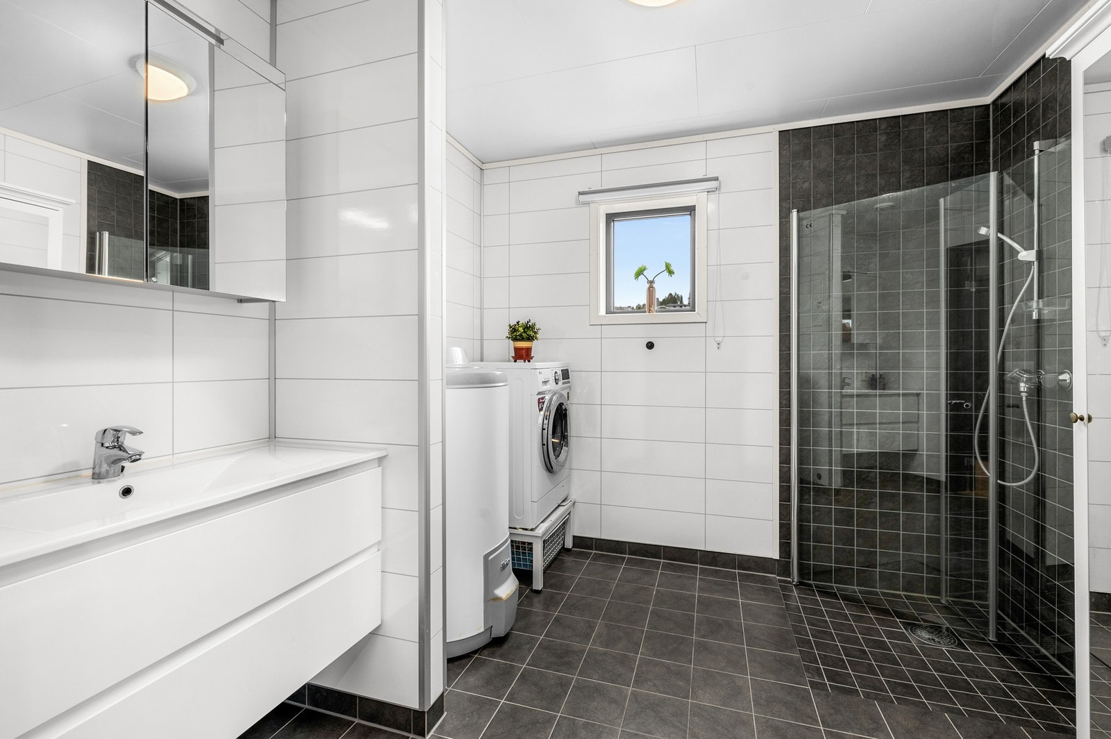 Stort og fint bad med fliser og opplegg for vaskemaskin Galleribilde