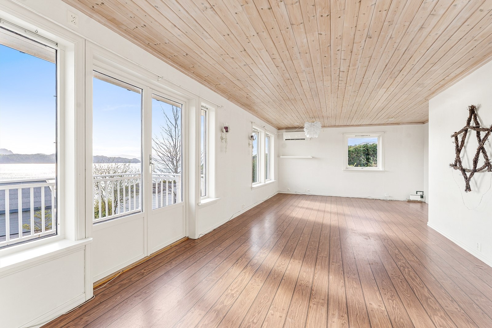 Lys og romslig stue med store vinduer som gir panoramautsikt over vakre, naturskjønne omgivelser Galleribilde