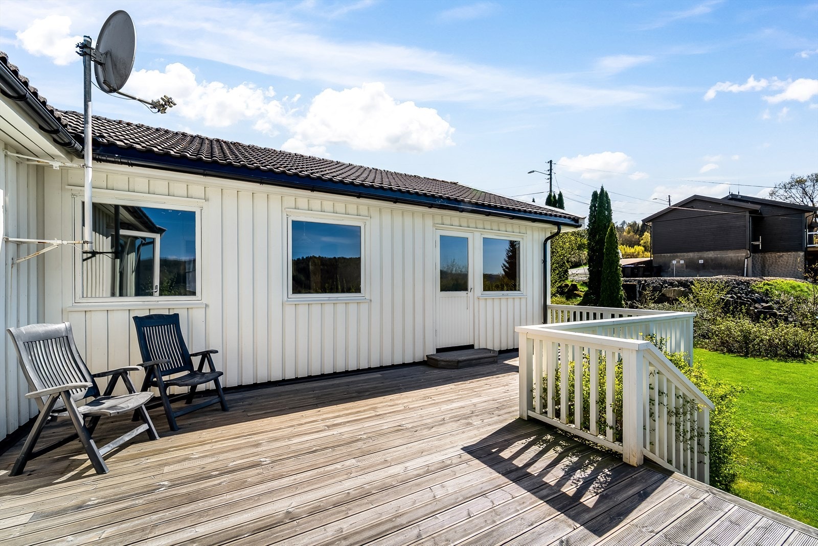 Solrik terrasse med nedgang til en pent opparbeidet hage. Galleribilde