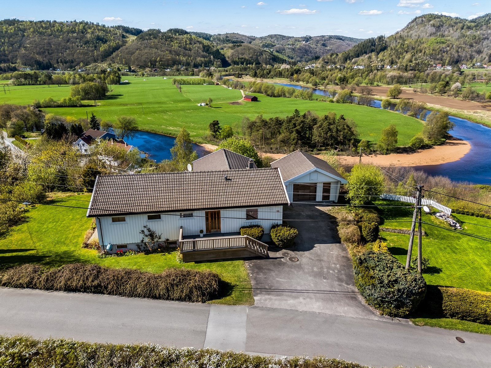 Boligen ligger fint plassert på en solrik og flat tomt med asfaltert innkjørsel og pent beplantet hage. Galleribilde