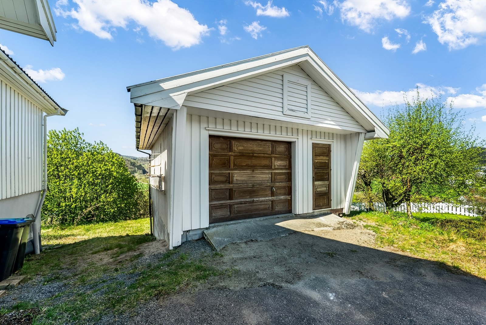 Garasje med automatisk portåpner og rom for lagring under. Galleribilde