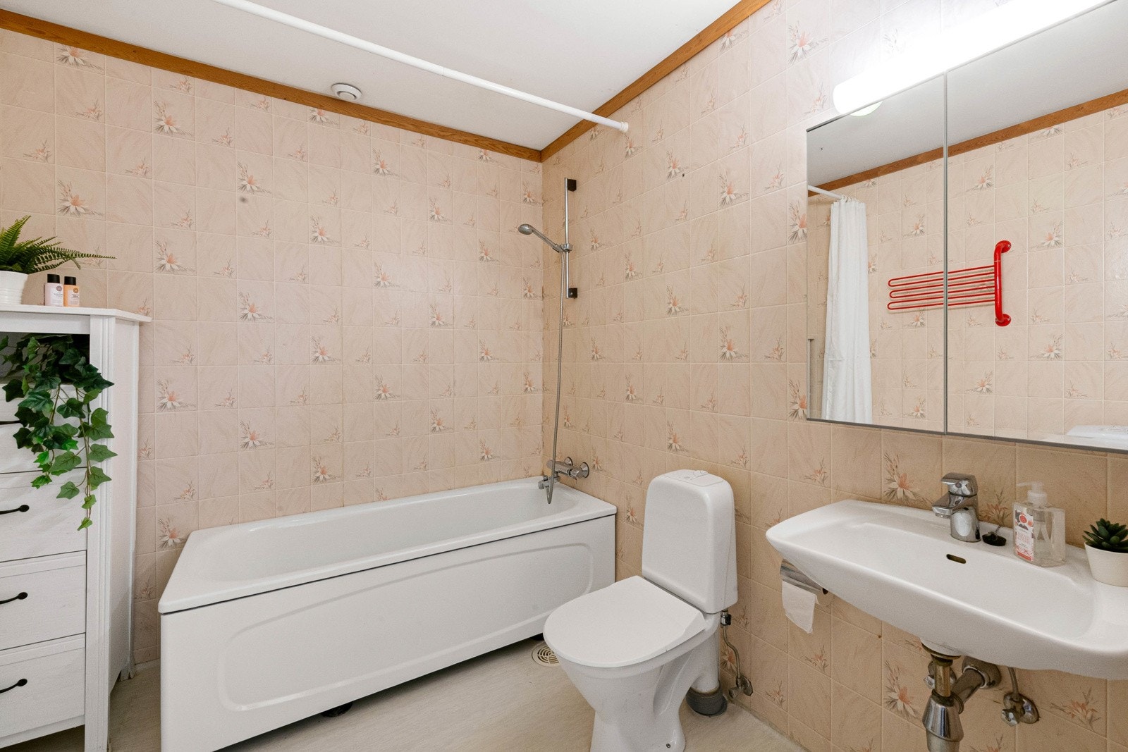 Eldre, men funksjonelt bad/WC/vaskerom, ca. 6 m². Badet har vinylbelegg på gulv. Tapet på vegger og malt tak. Galleribilde