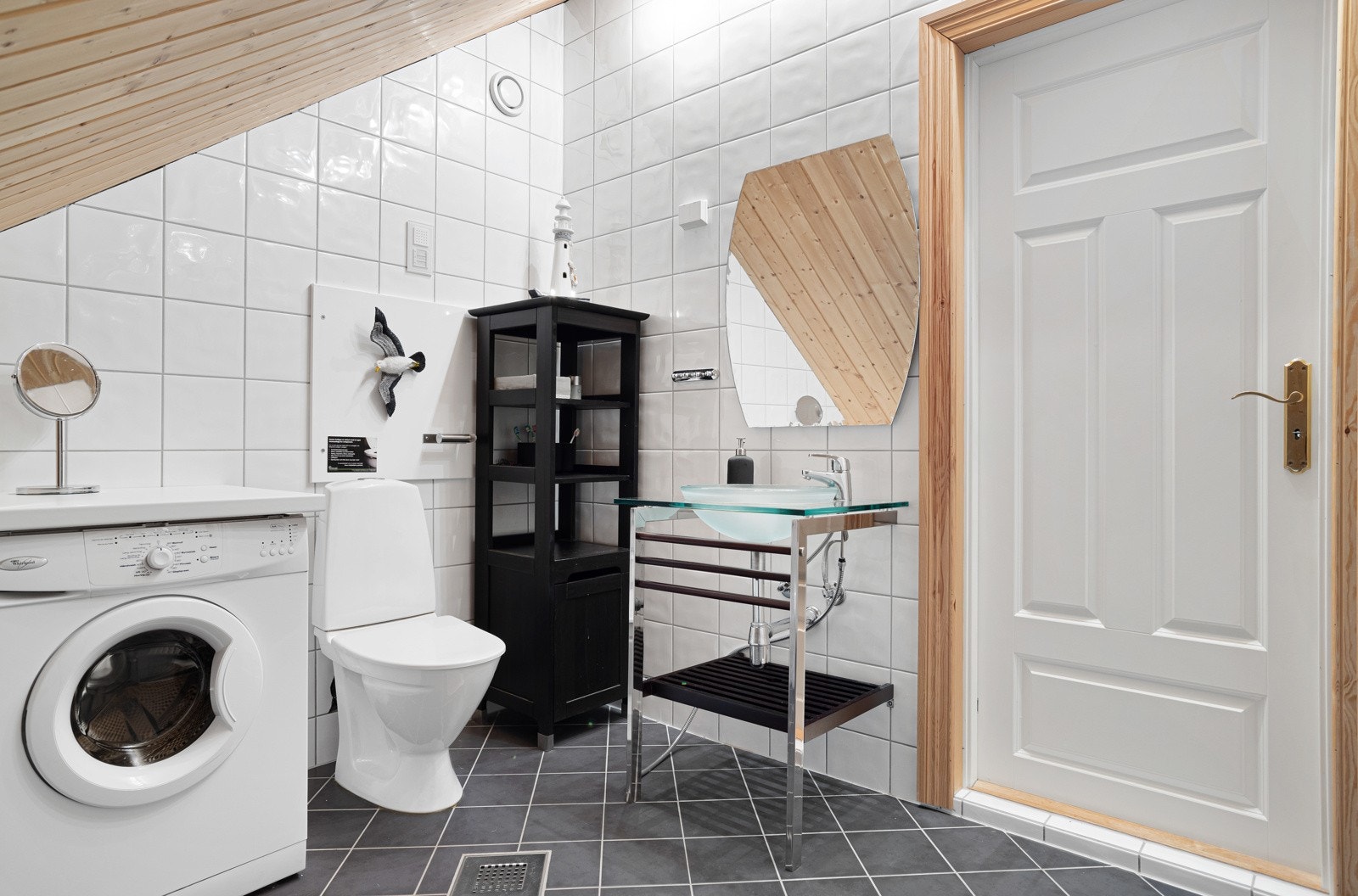 Stort bad med opplegg til vaskemaskin, dusj, toalett og servant med innredning. Galleribilde