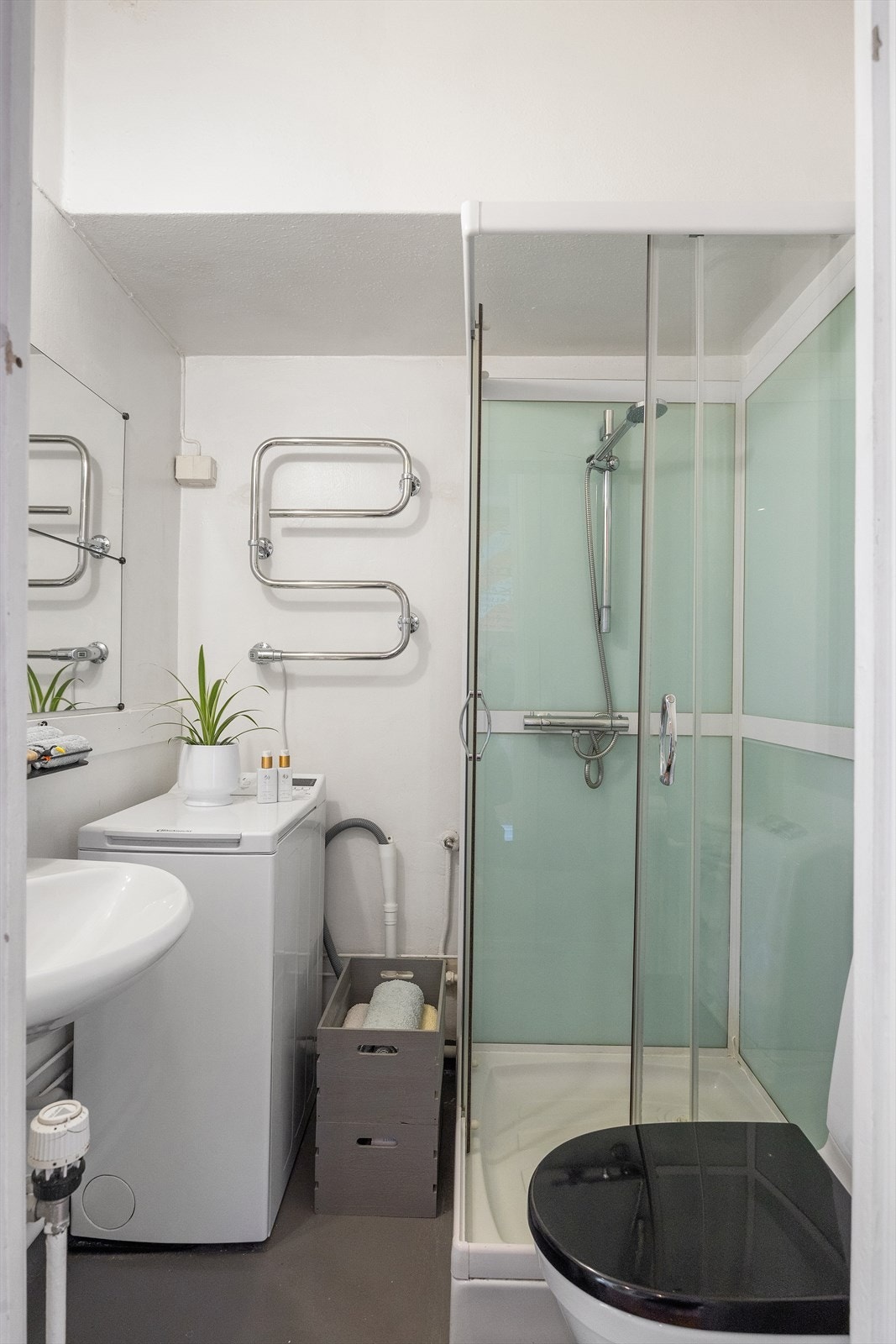 Eldre baderom innredet med klosett, servant og dusjkabinett. Opplegg for vaskemaskin. Radiator tilknyttet vannbåren varme. Rommet har naturlig avtrekk. Galleribilde