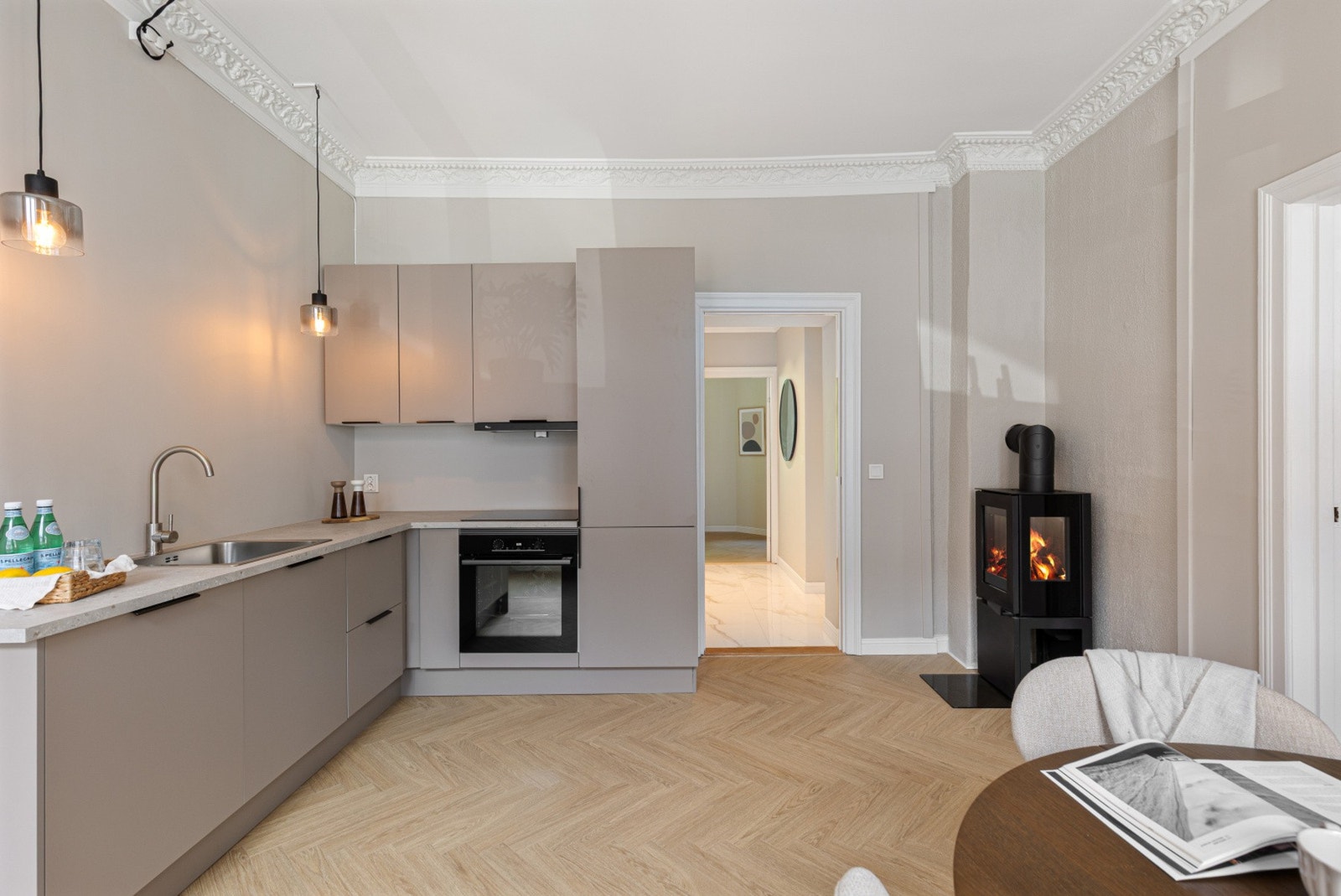 Kjøkkenet fra 2025 er levert av HTH med glatte fronter, laminat benkeplate og nedfelt kum i rustfritt stål Galleribilde