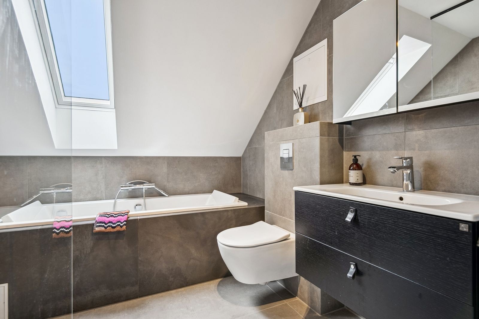 Bad i 2. etasje med badekar, dusj, toalett, servant og vindu som gir naturlig lys inn på badet. Galleribilde