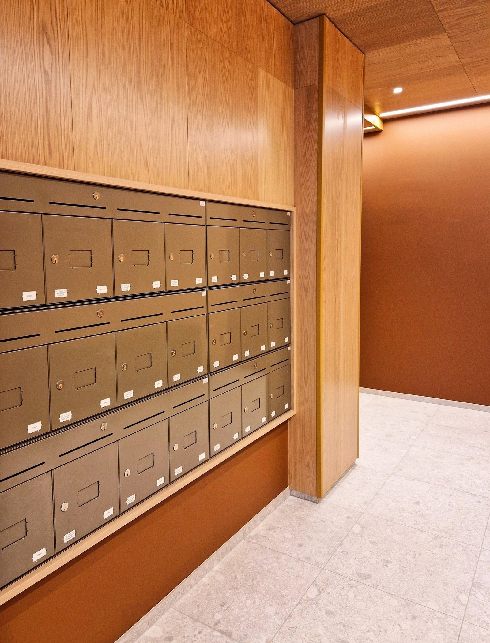 Inngangspartiet har store steinfliser og treverk Galleribilde