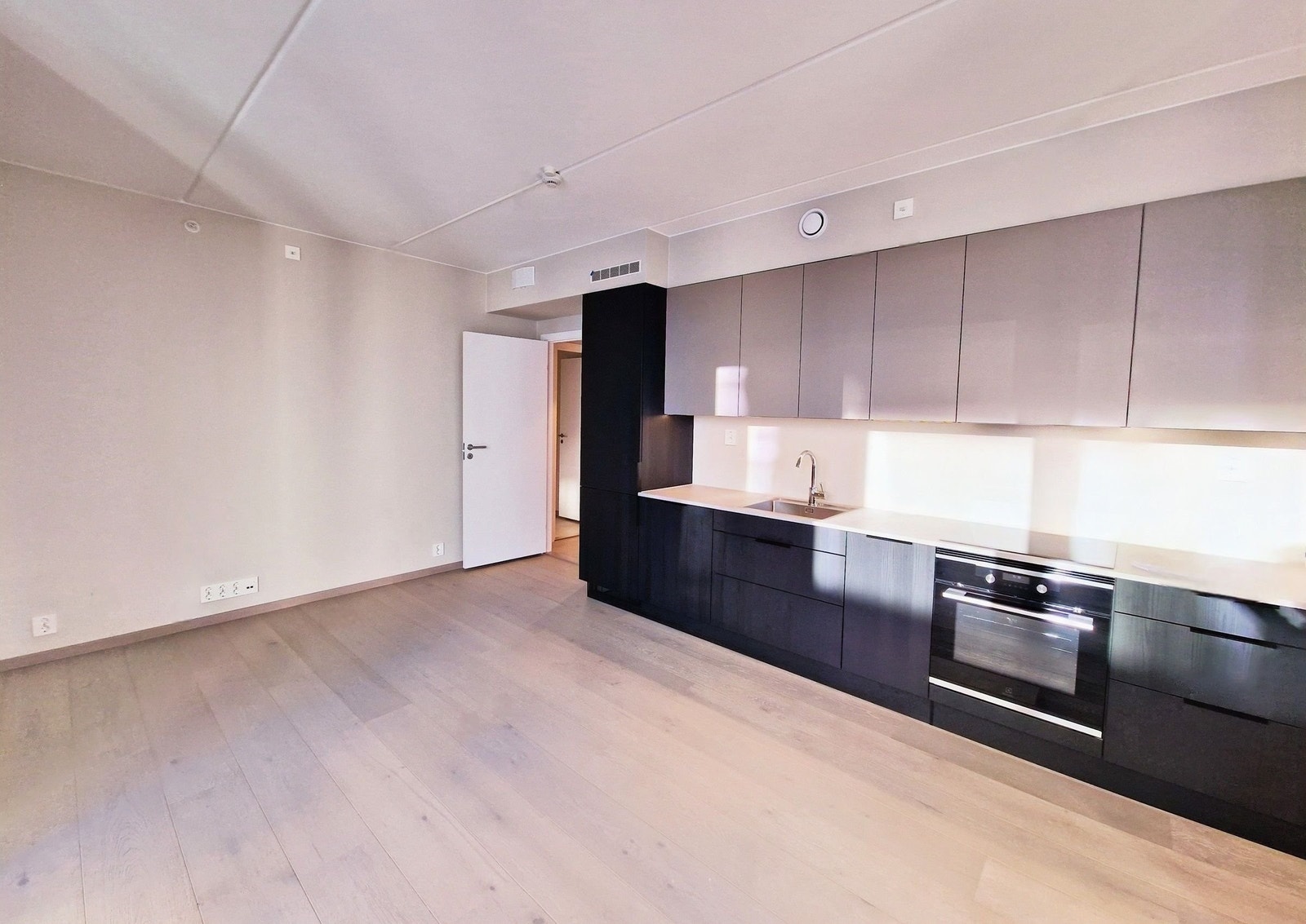 Kjøkkenløsningen har slette fronter i to fargetoner Galleribilde