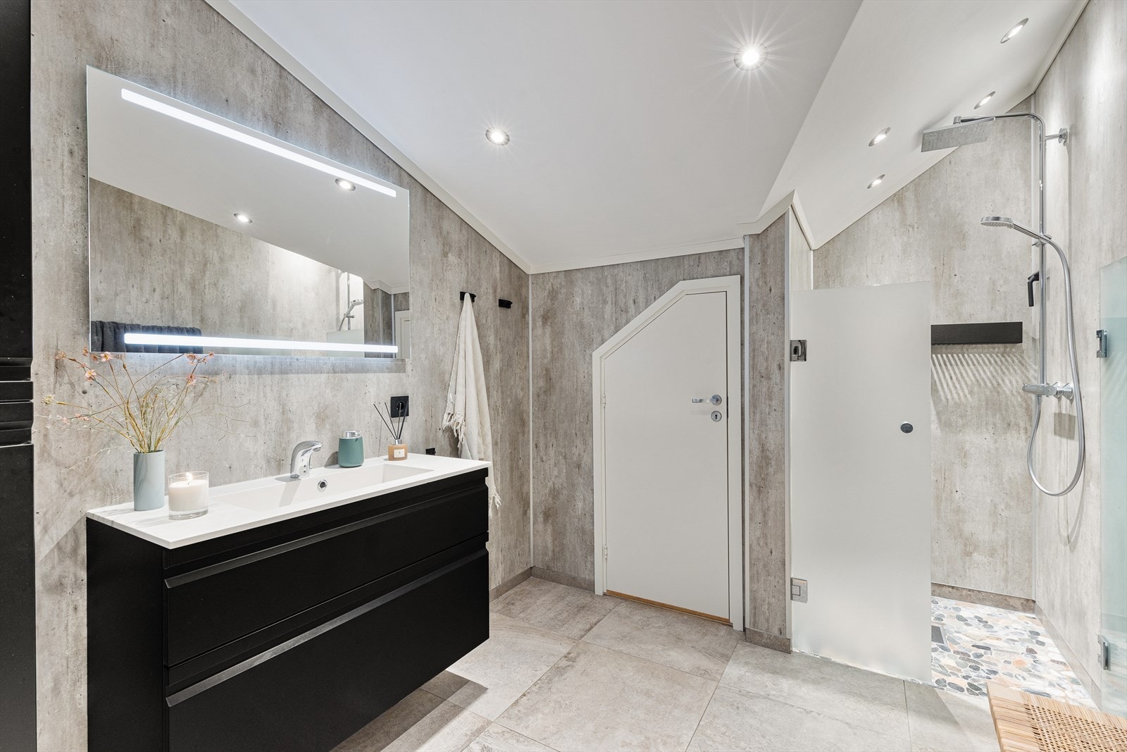 Badet i 1. etg. inneholder wc, dusjhjørne, håndvask med tilpassede skuffer og skap. Galleribilde