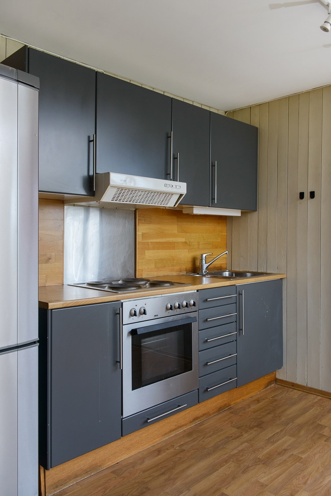 Delikat gråtone på kjøkkeninnredningen. Over-og underskap, samt skuffer for oppbevaring. Galleribilde