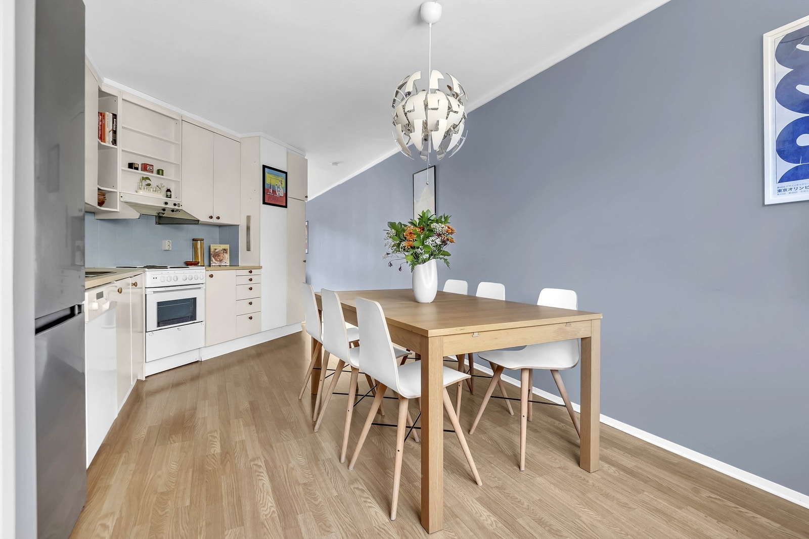 Kjøkkeninnredning med slette fronter, benkeplater av laminat, nedfelt oppvaskkum med to-greps armatur og fliser mellom kjøkkenbenk og overskap. Galleribilde