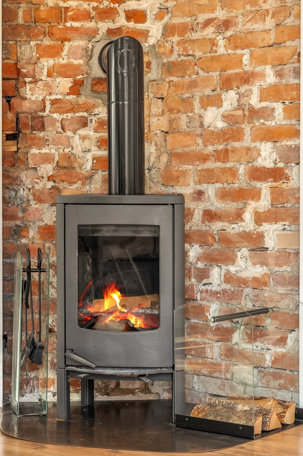 I stuen er det montert en peisovn tilknyttet teglsteinspipen som ble rehabilitert med nytt innvendig stålrør i 2016 Galleribilde