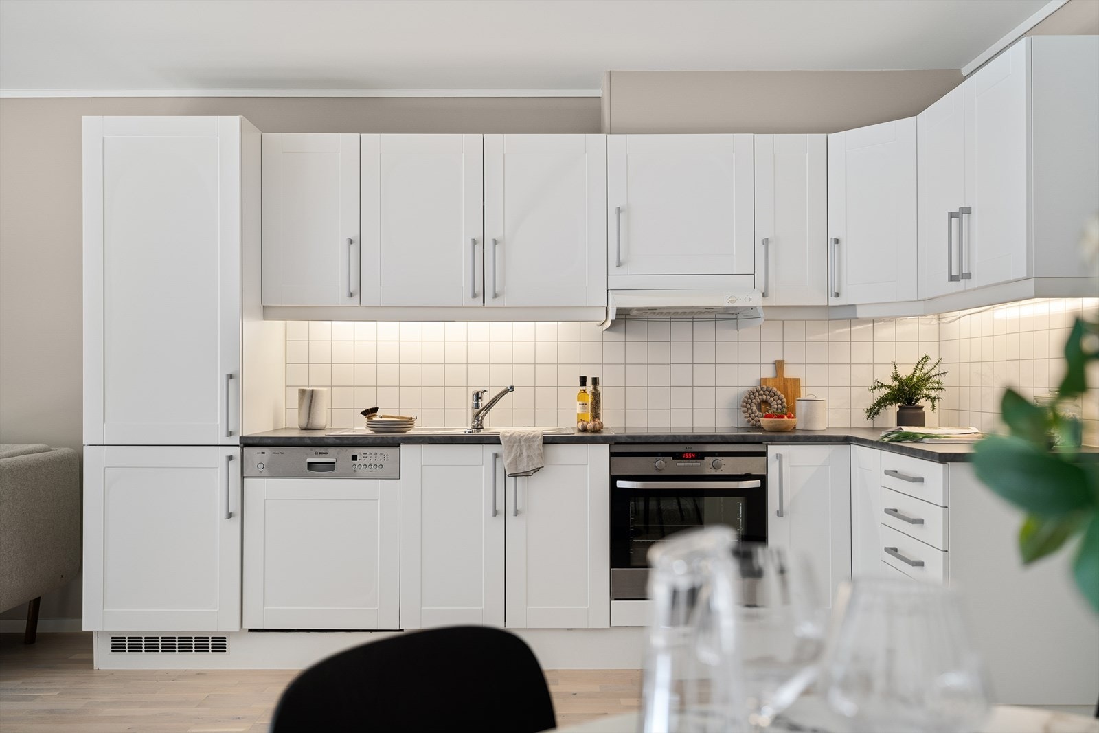 Benkeplaten er i laminat, og mellom benk og overskap er det montert kitchen boards som gjør det enkelt å holde rent. Galleribilde