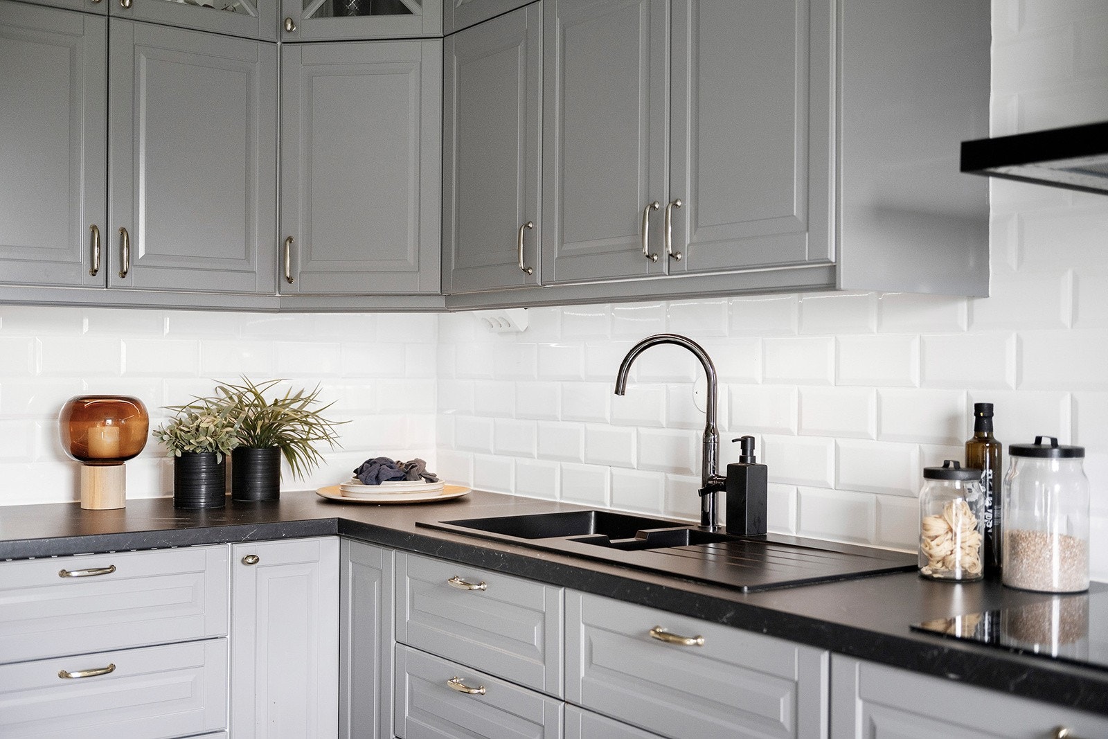 Innbydende kjøkkeninnredning fra 2018 med profilerte fronter og fliser over laminert benkeplate. Galleribilde