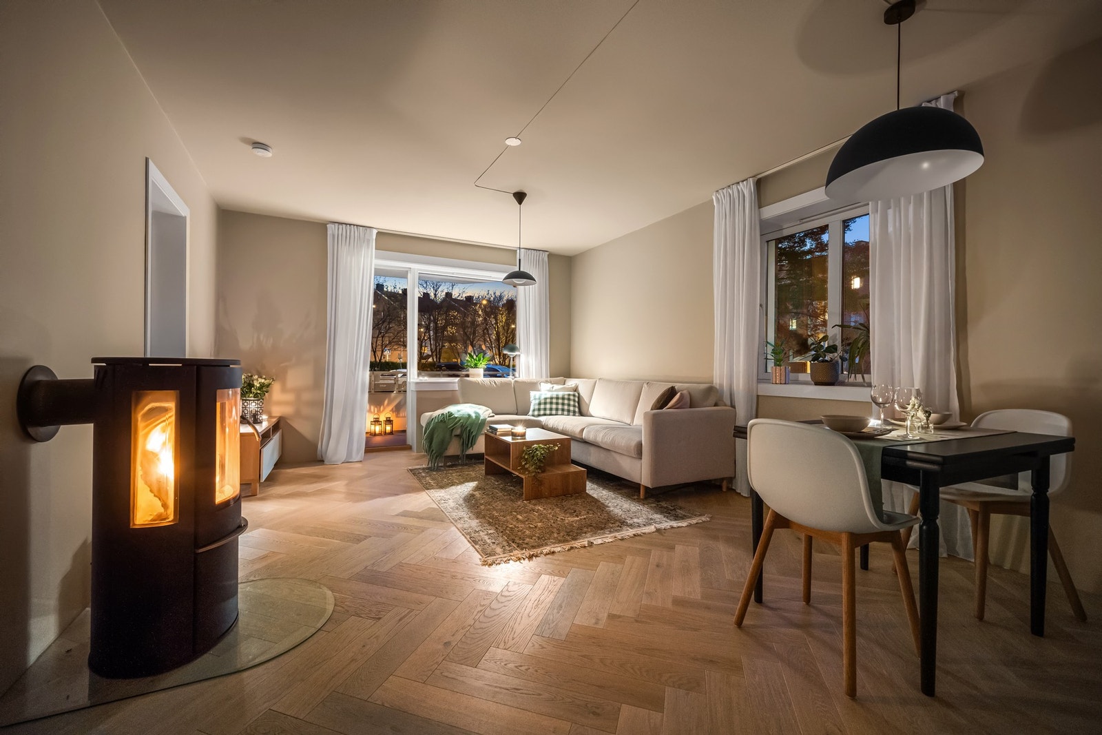 Kveldsmodus i stuen og peisen er fyrt opp Galleribilde