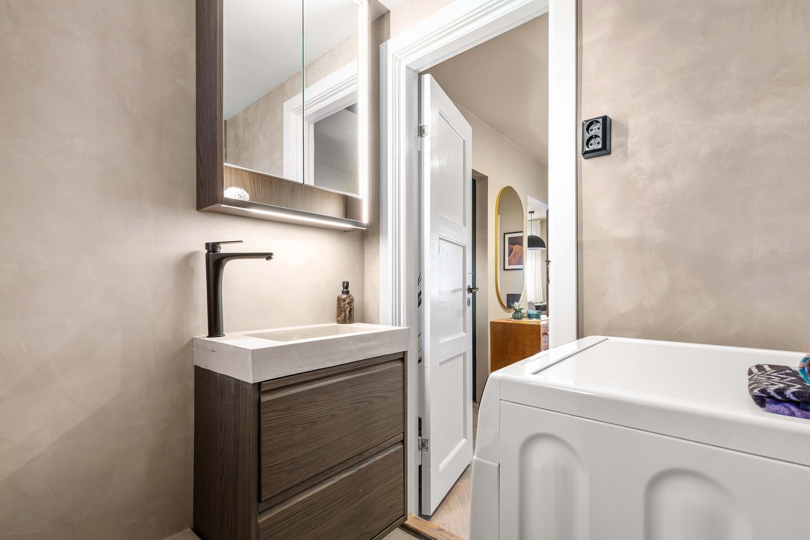 Servantinnredning i røkt eik med heldekkende servant, speilskap og et ekstra veggskap Galleribilde