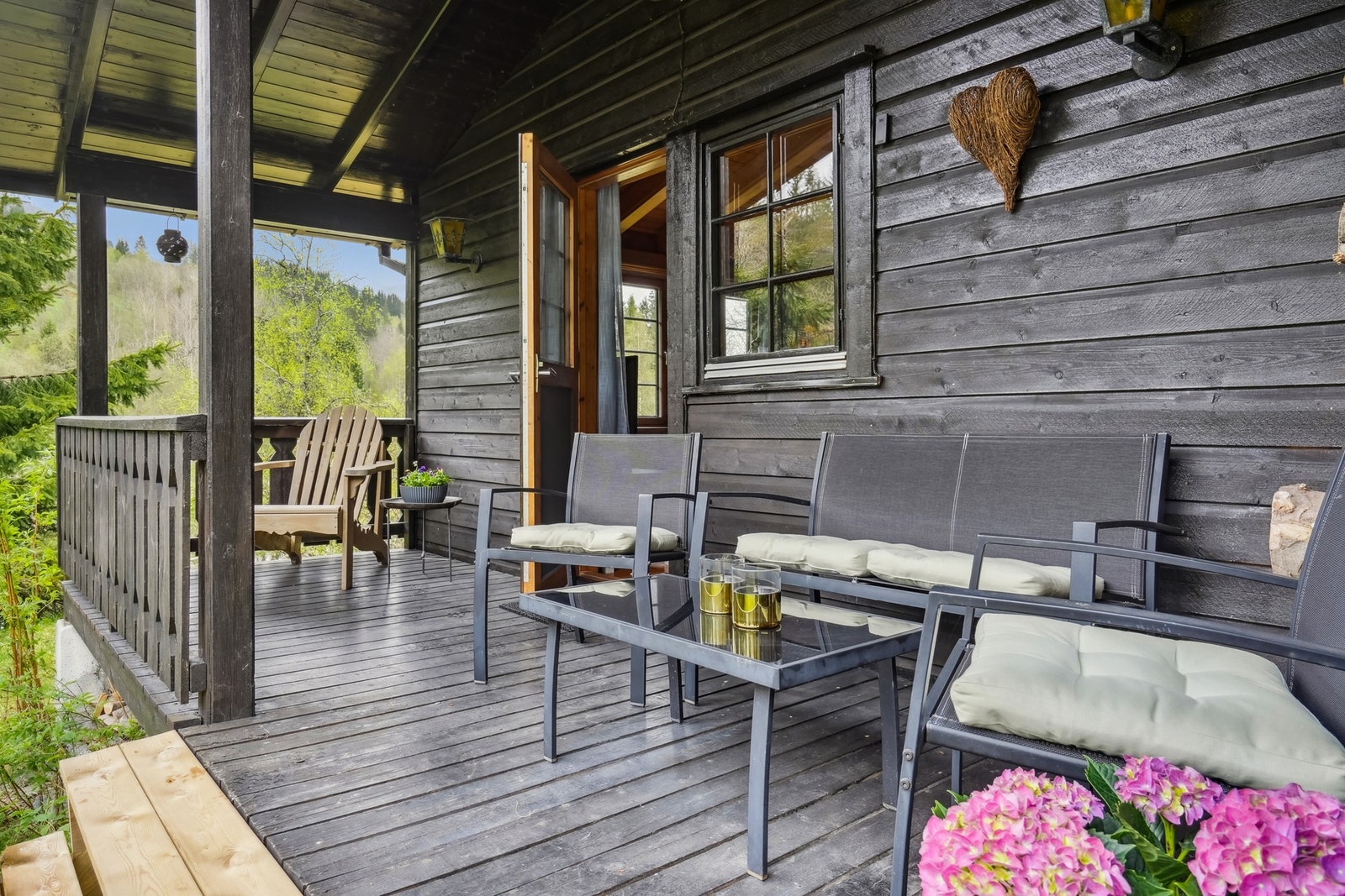 Verandaen har trapp ned til hage. Det er montert lampe på vegg Galleribilde