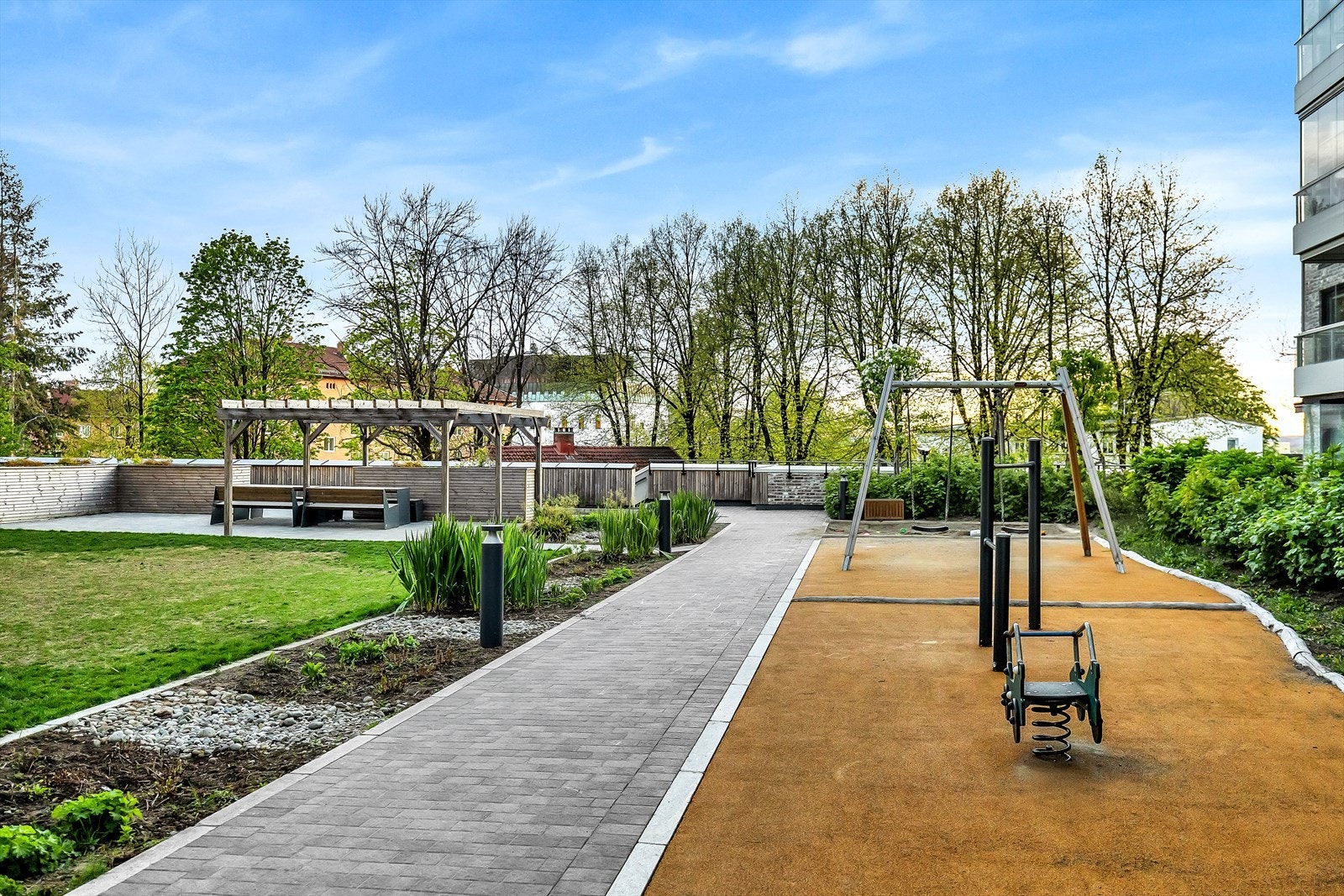 Pent opparbeidede fellesområder med sittegrupper, grøntområder og lekeplass. Galleribilde