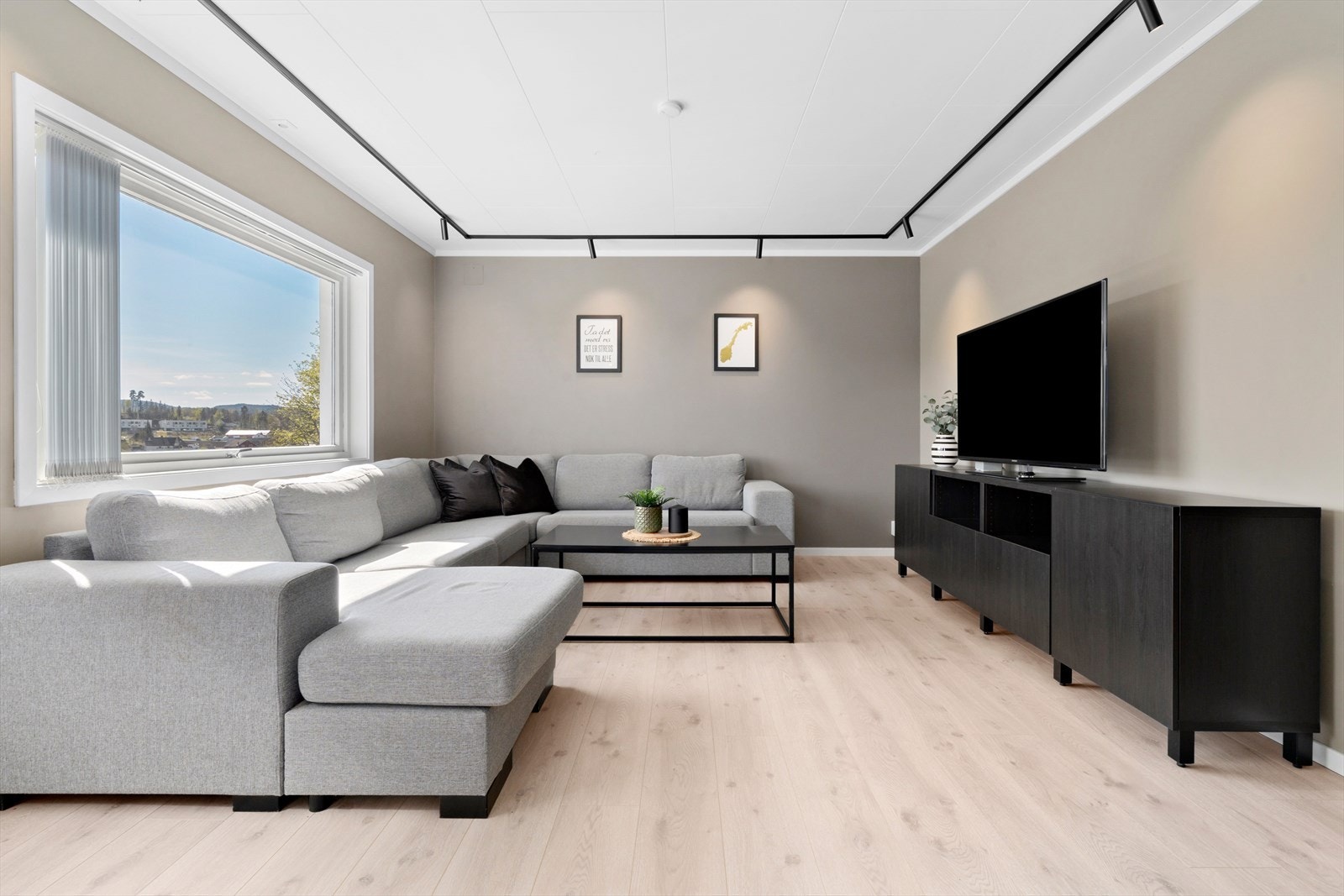 Lyse overflater med moderne laminatgulv og glatte, malte vegger skaper et stilrent og tidløst uttrykk. Galleribilde