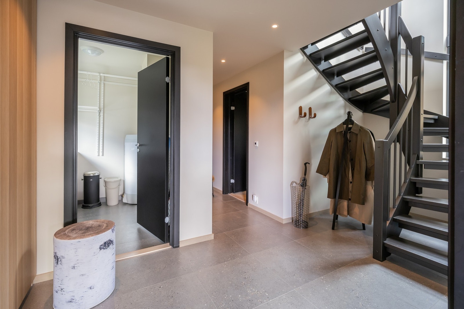 Innbydende og lekker hall med flislagte gulv med varme, stilrene overflater og romslig garderobe. Galleribilde