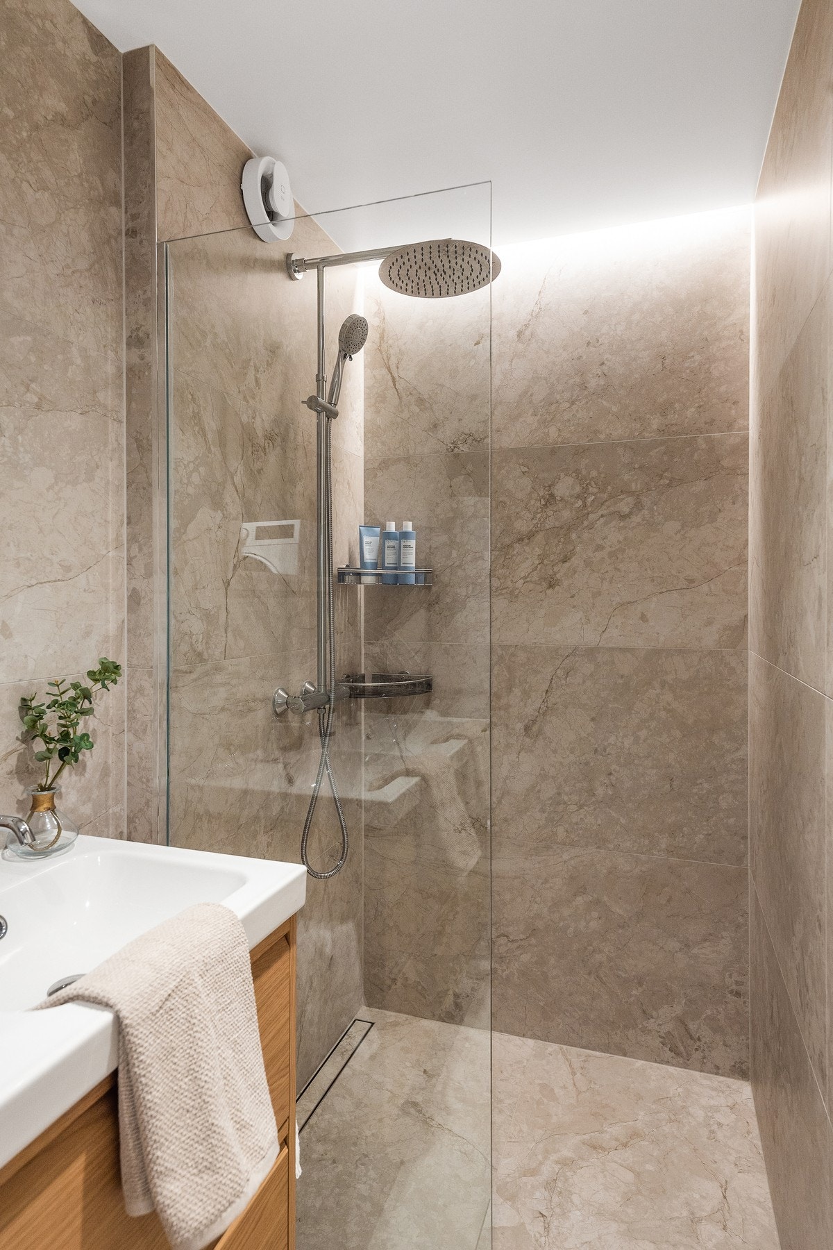 Dusjnisjen er praktisk utformet med glassvegg og moderne dusjarmatur med både hånddusj og regndusj. Galleribilde